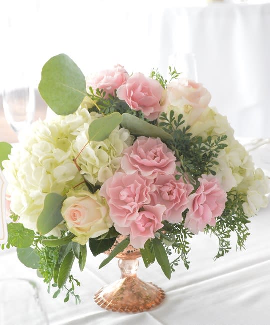 Pink and white roses arranged in a glass vase