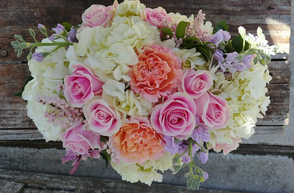 Pink and peach roses with white hydrangeas in a bouquet