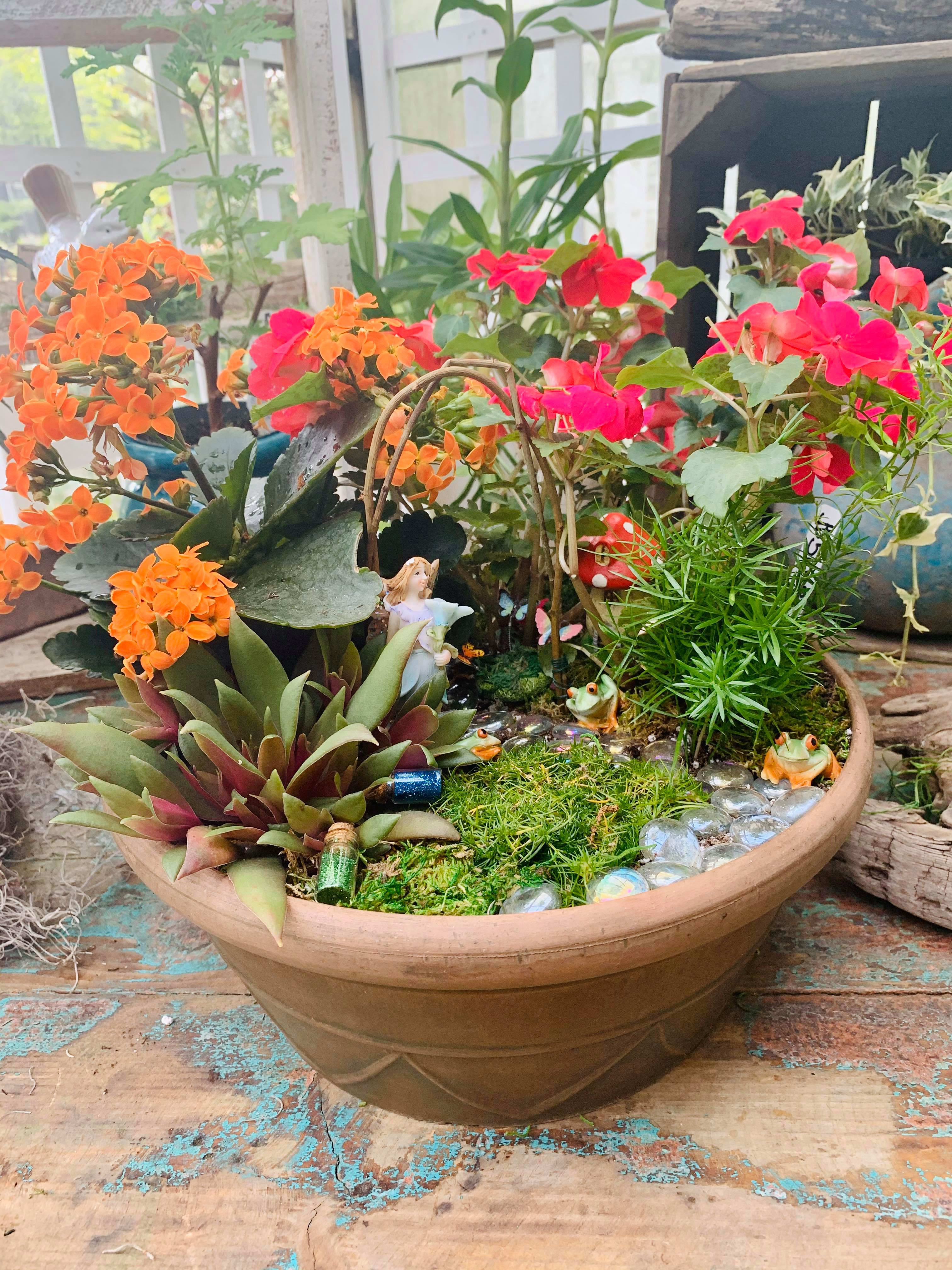 Succulent planter with orange and pink flowers in a shallow bowl