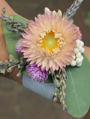 Small boutonniere with a pale peach flower and purple accents