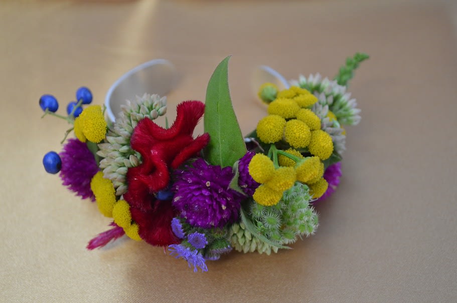 Colorful floral wrist corsage with yellow, purple, red, and blue blooms