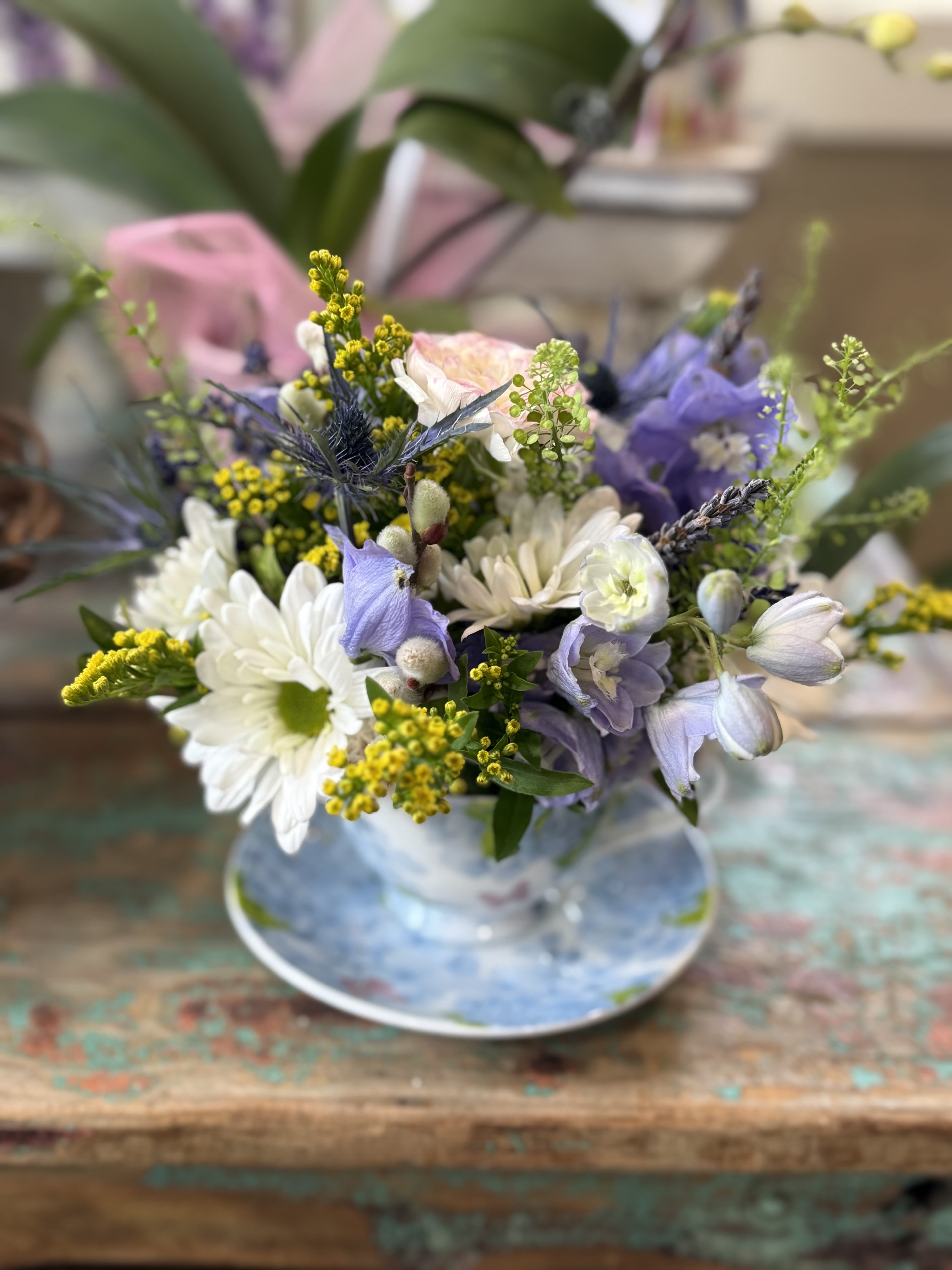 Pastel bouquet of white daisies and lavender blooms in a glass vase