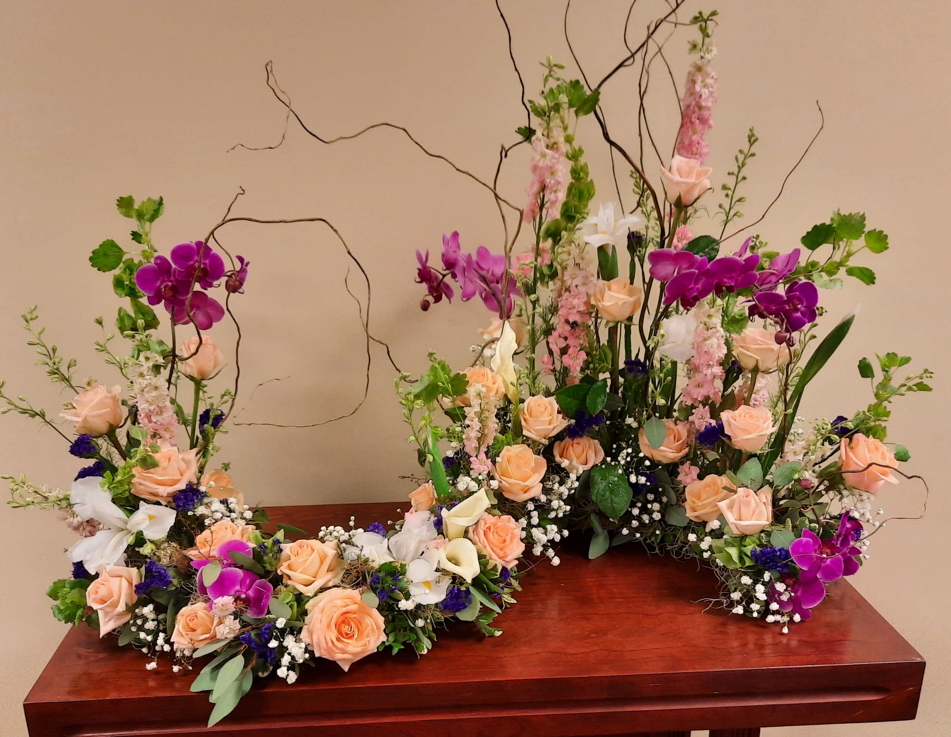 Floral arrangement with peach roses, white lilies, and purple orchids