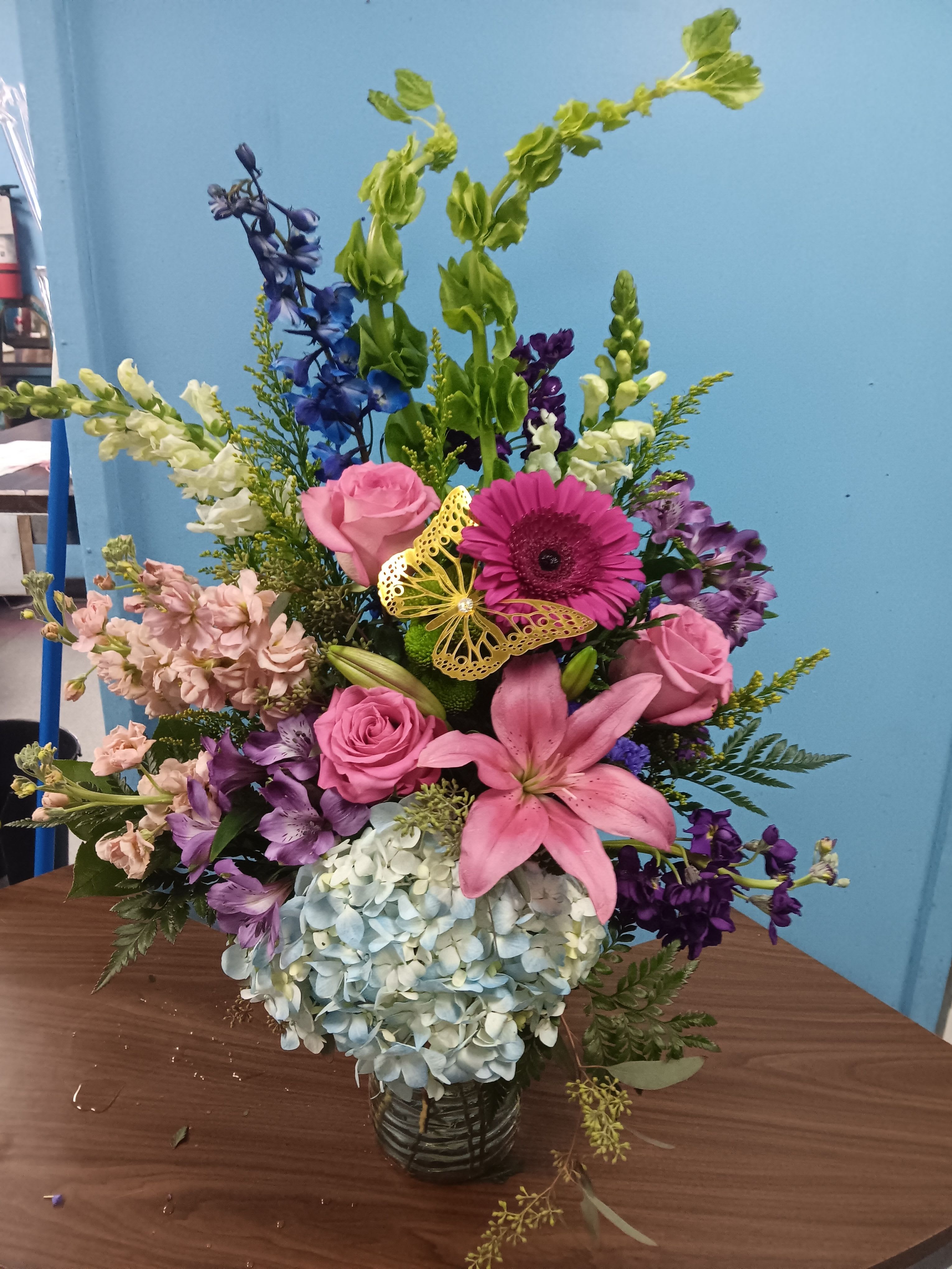 Enchanting Fairytale - This arrangement contains stargazer lilies, bells of ireland, stock, blue iris, roses, carnations, and purple aster. This is a great gift for birthday, Mother's Day, love and romance, or to say thank you. APPROXIMATE DIMENSIONS: 16" D x 26" H