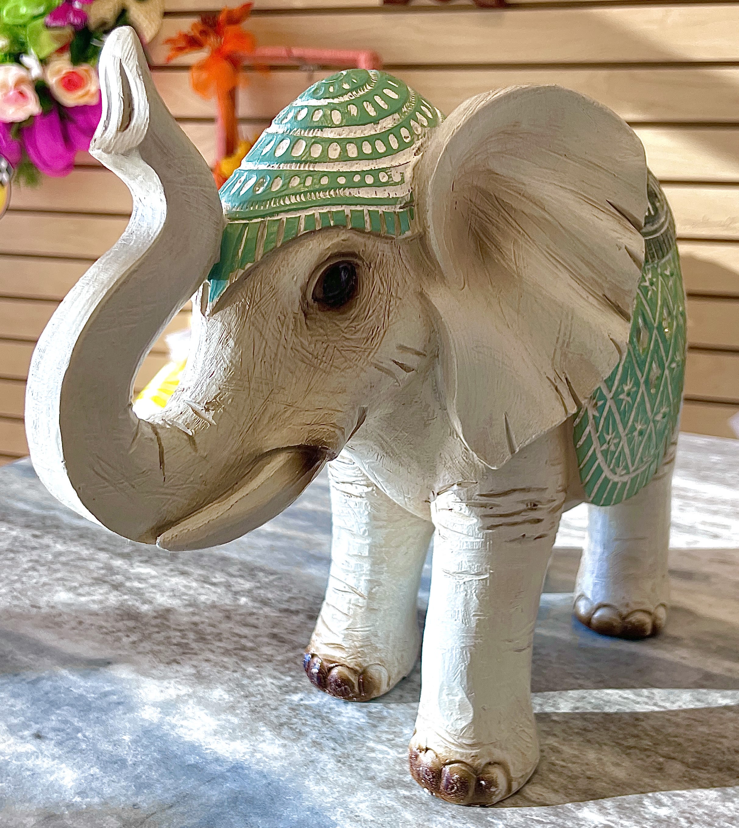 Decorative carved elephant figurine with green painted accents