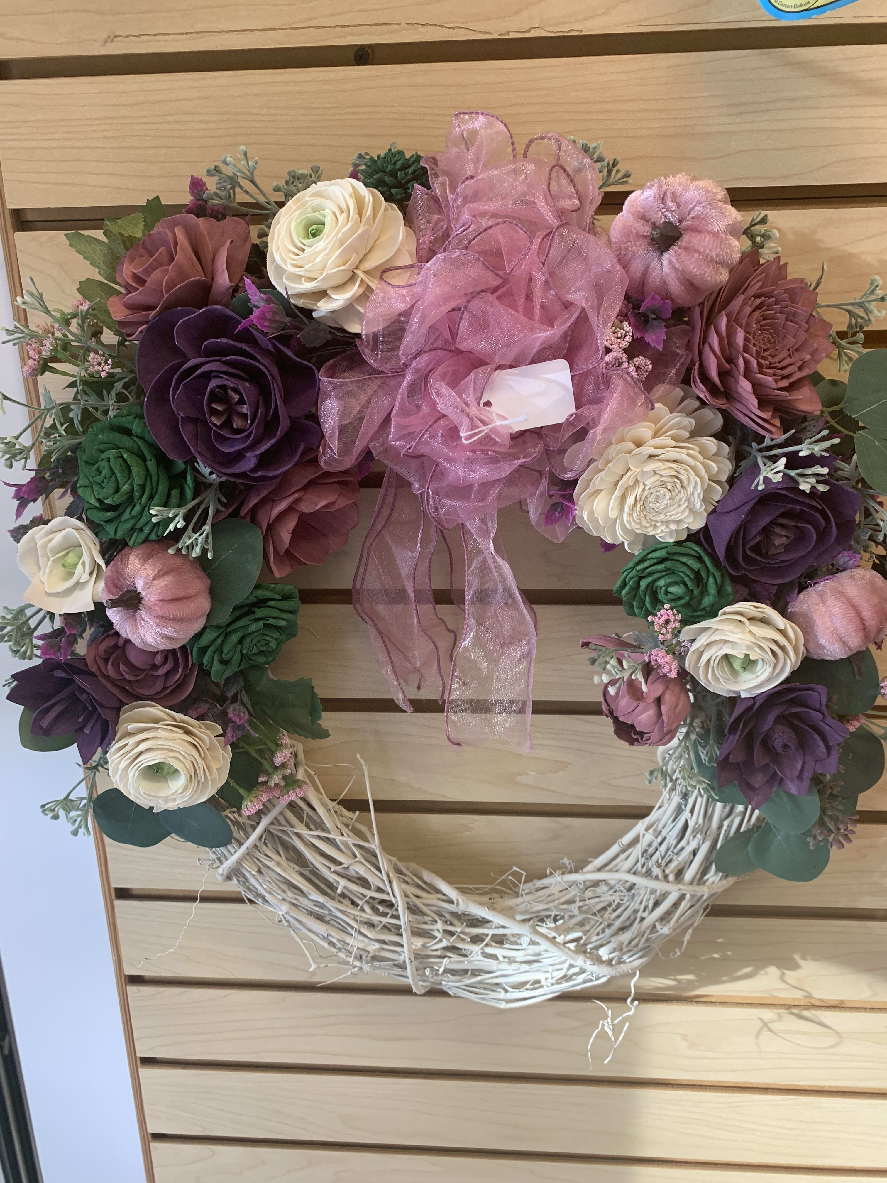 Heart-shaped floral wreath with pink ribbon and mixed blooms