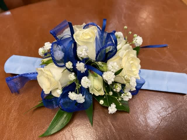 White rose corsage with blue ribbon and baby's breath