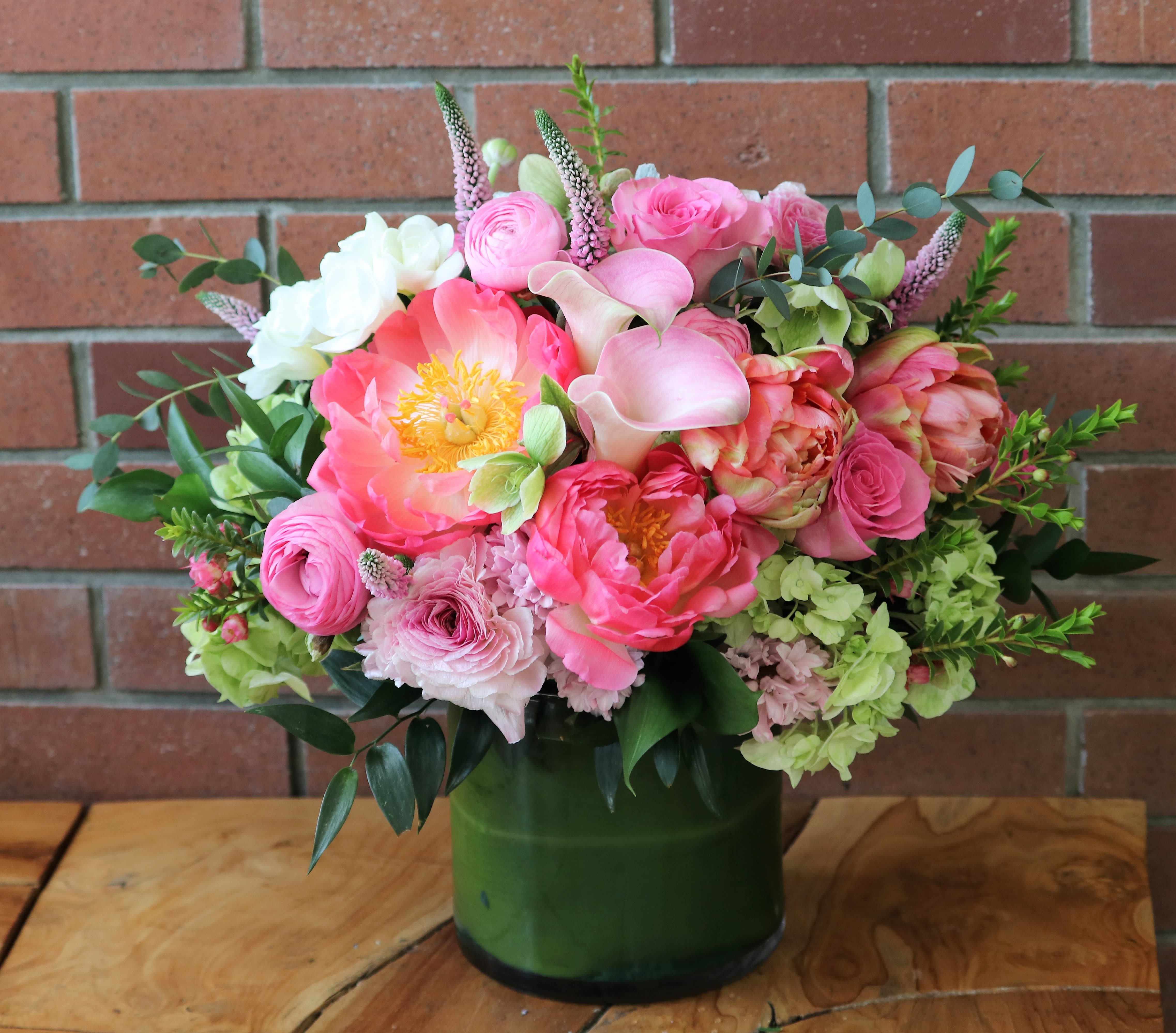 Pink and white mixed bouquet in a green glass vase