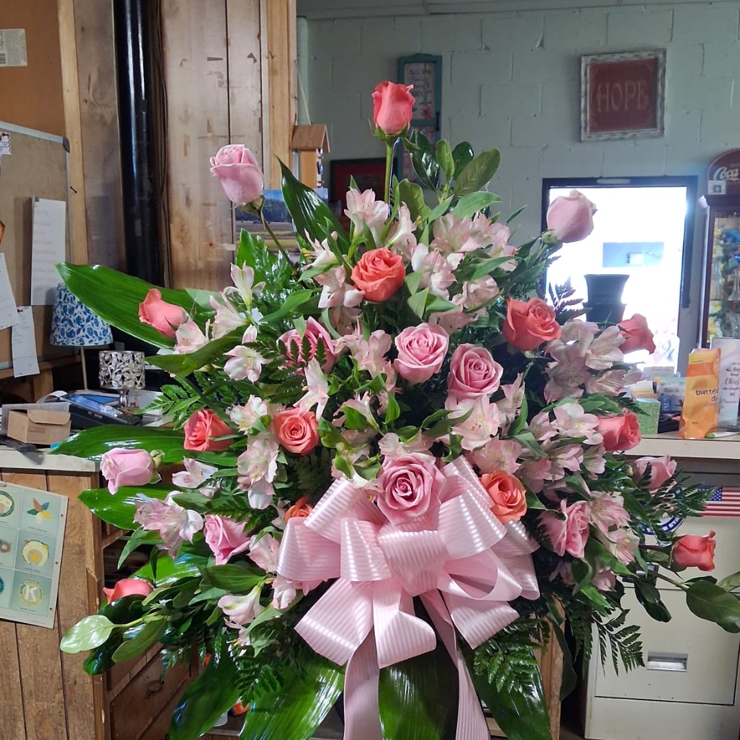 Large pink rose and lily arrangement with a pink ribbon bow