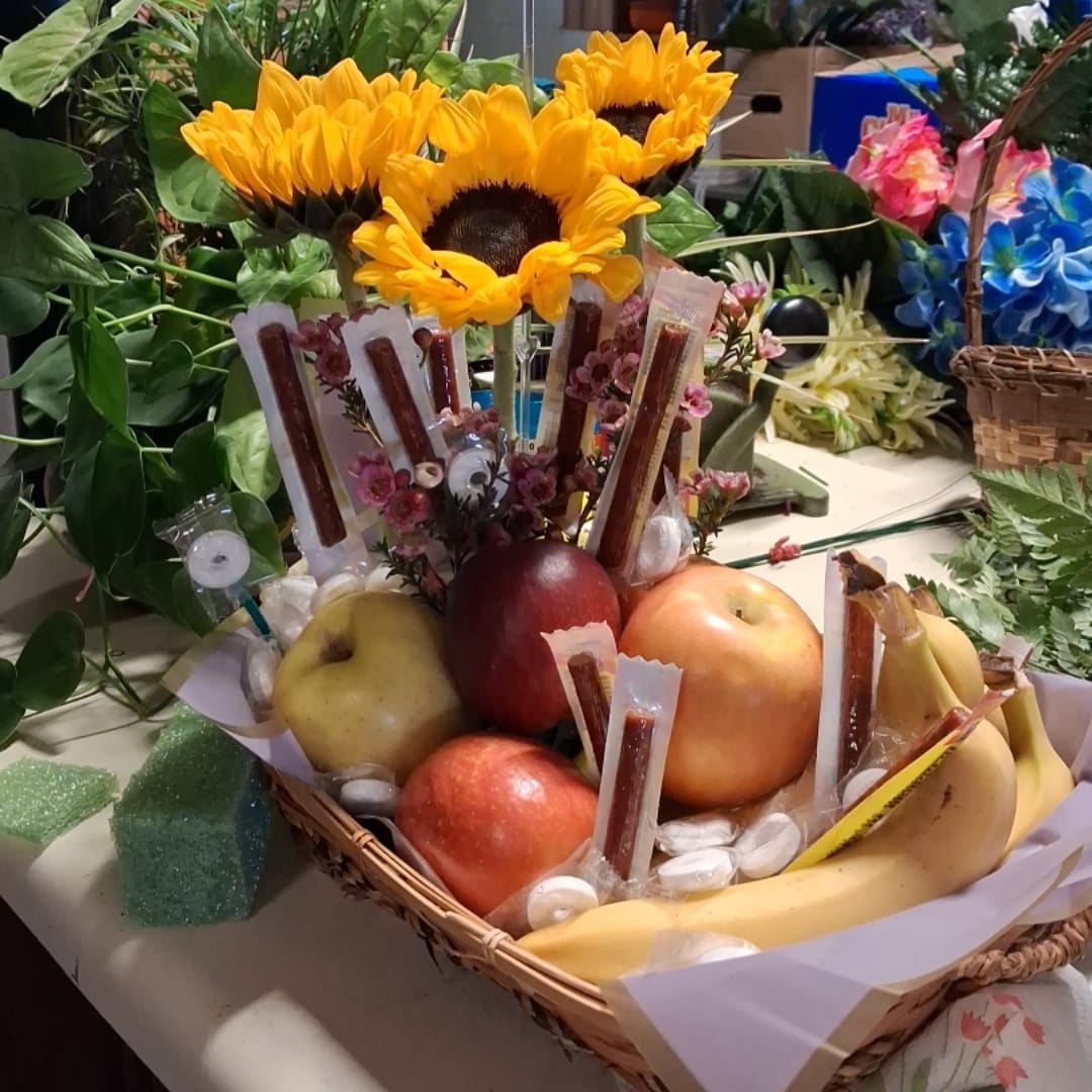 Fruit basket with sunflowers and assorted fruit in a wicker tray