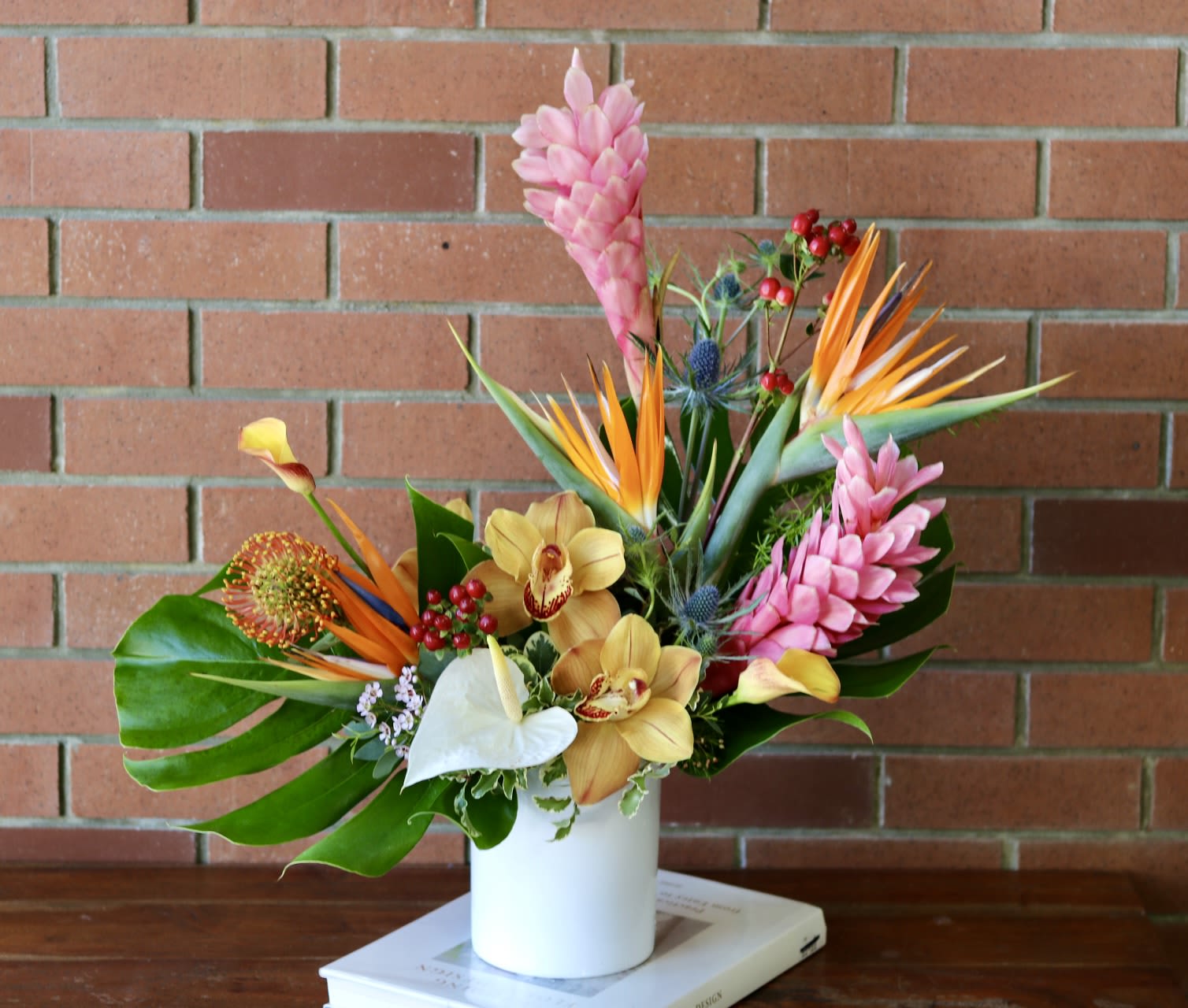 Tropical bouquet in a white vase with pink and orange flowers