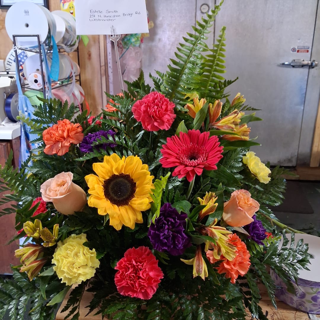 Colorful mixed flower arrangement with sunflowers, carnations, roses, and lilies