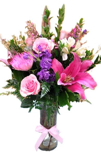 Pink and purple mixed bouquet in a glass vase with a ribbon