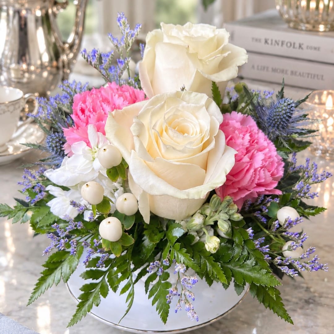 Cream roses and pink carnations in a low white vase