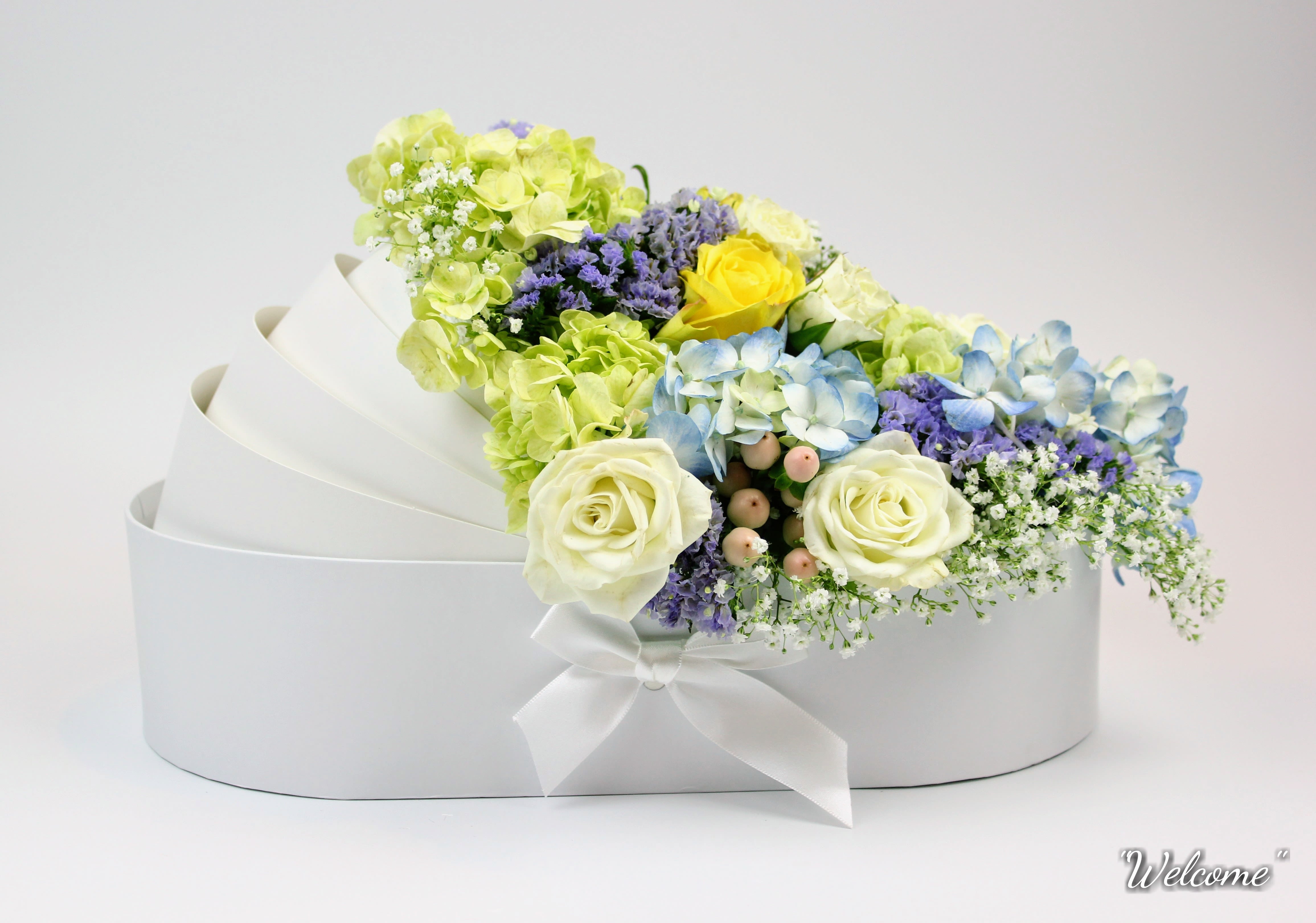 White hatbox arrangement with pastel roses, hydrangeas, and filler flowers