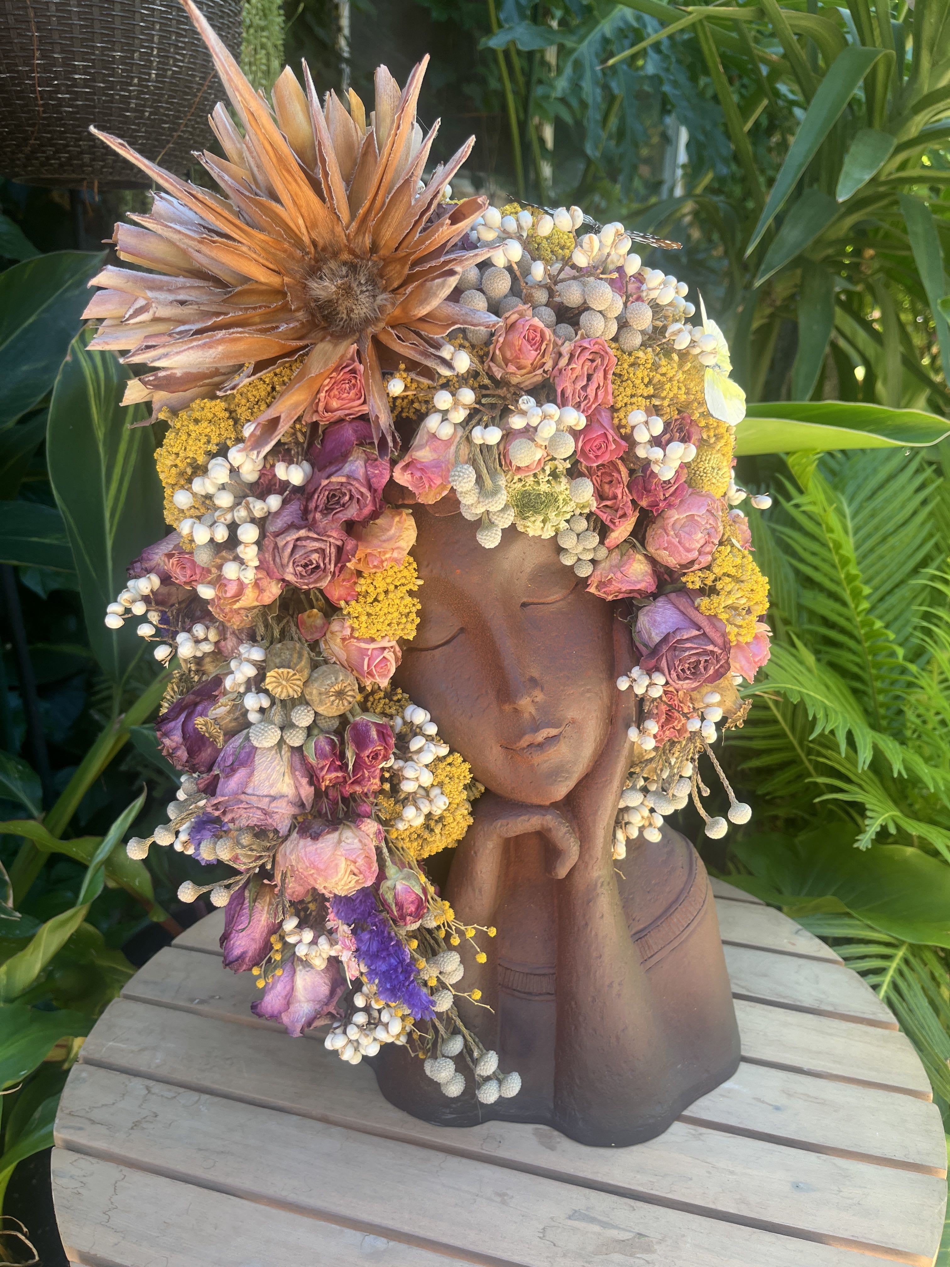 Floral crown on a sculpted bust with pink and purple dried flowers