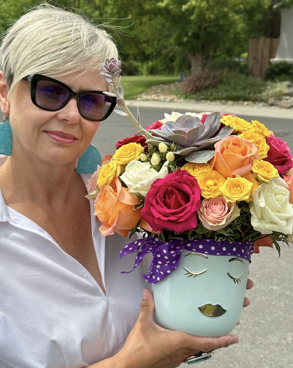 Woman holding a colorful bouquet in a painted face vase