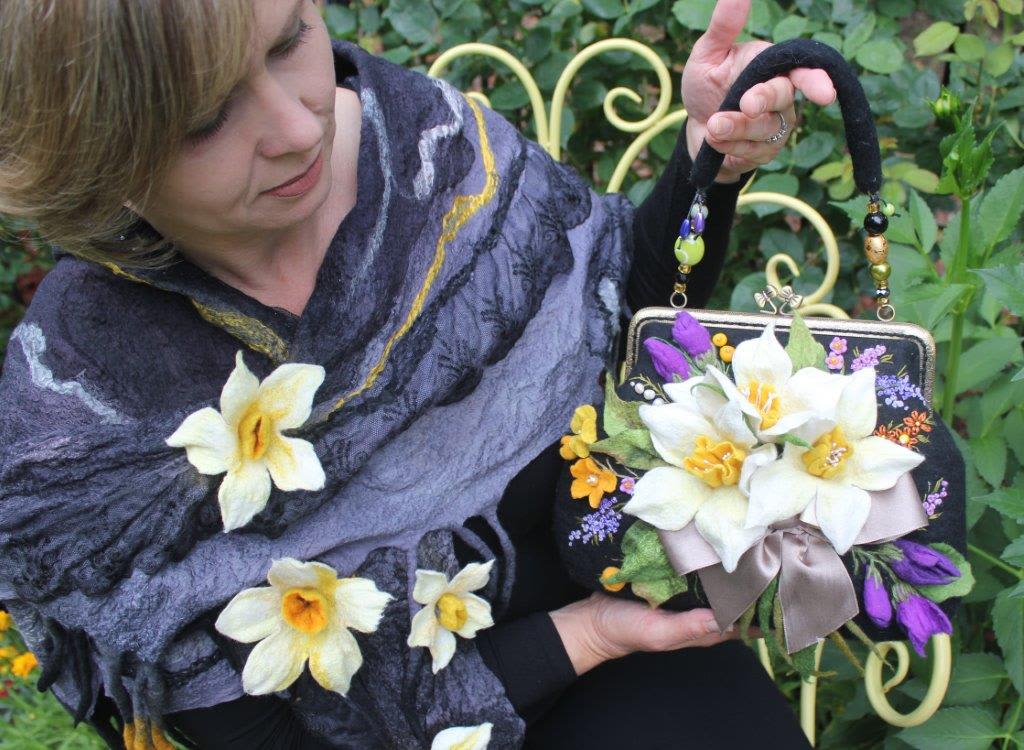 Woman holding a floral handbag decorated with white and purple flowers