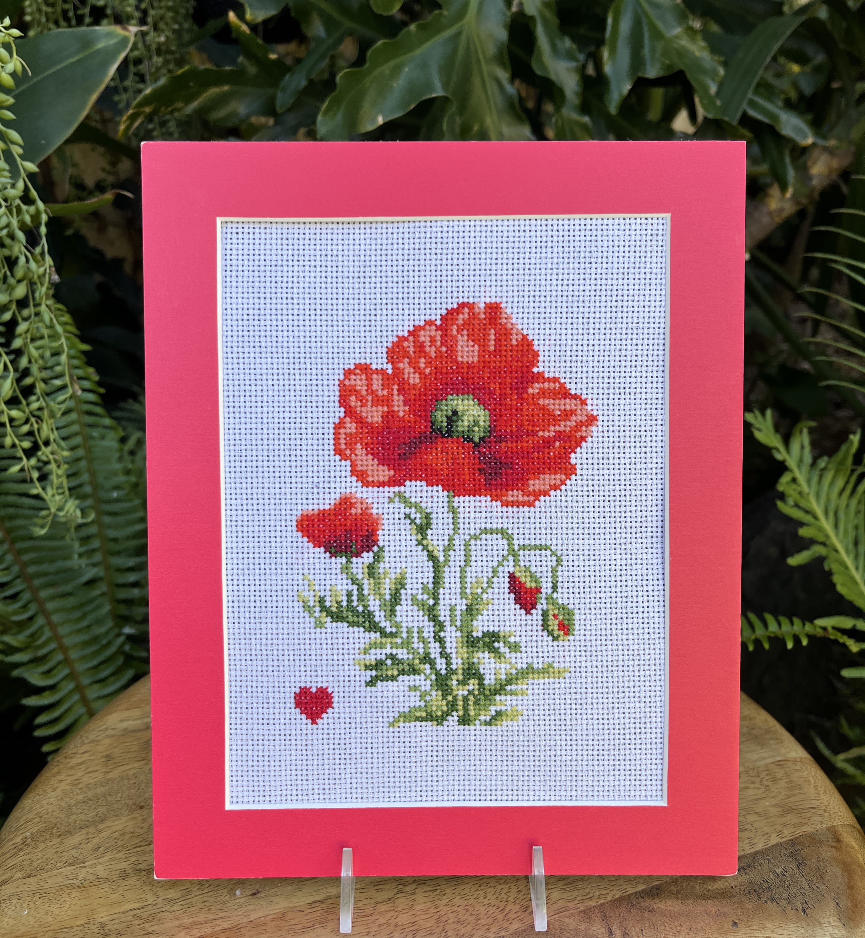 Framed cross-stitch of a red poppy flower