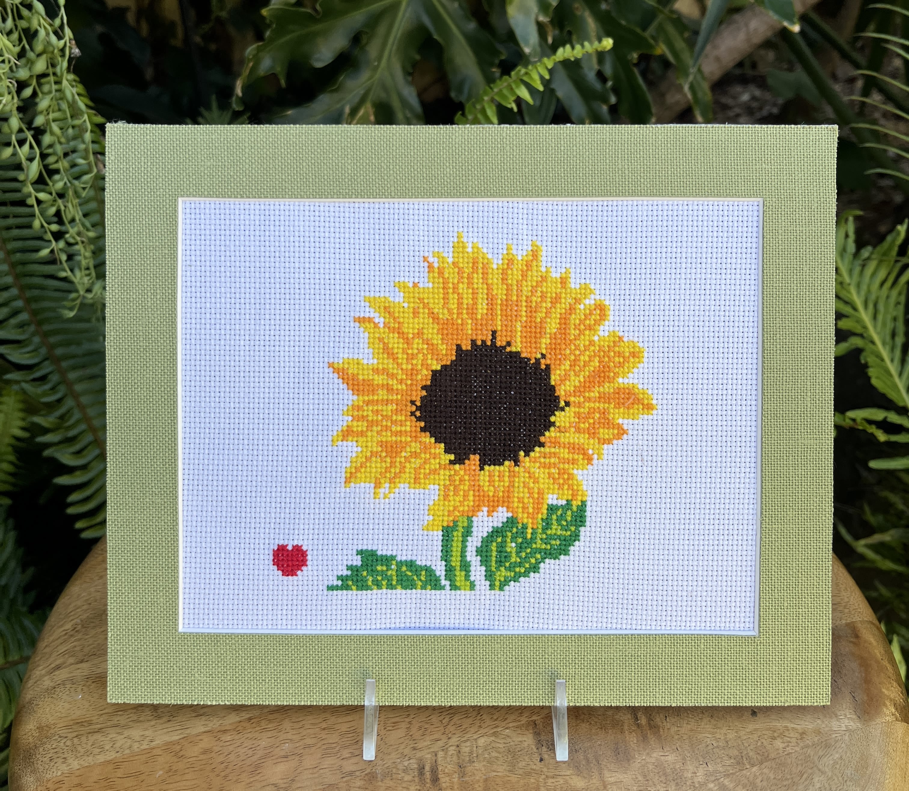 Framed sunflower cross-stitch on a stand