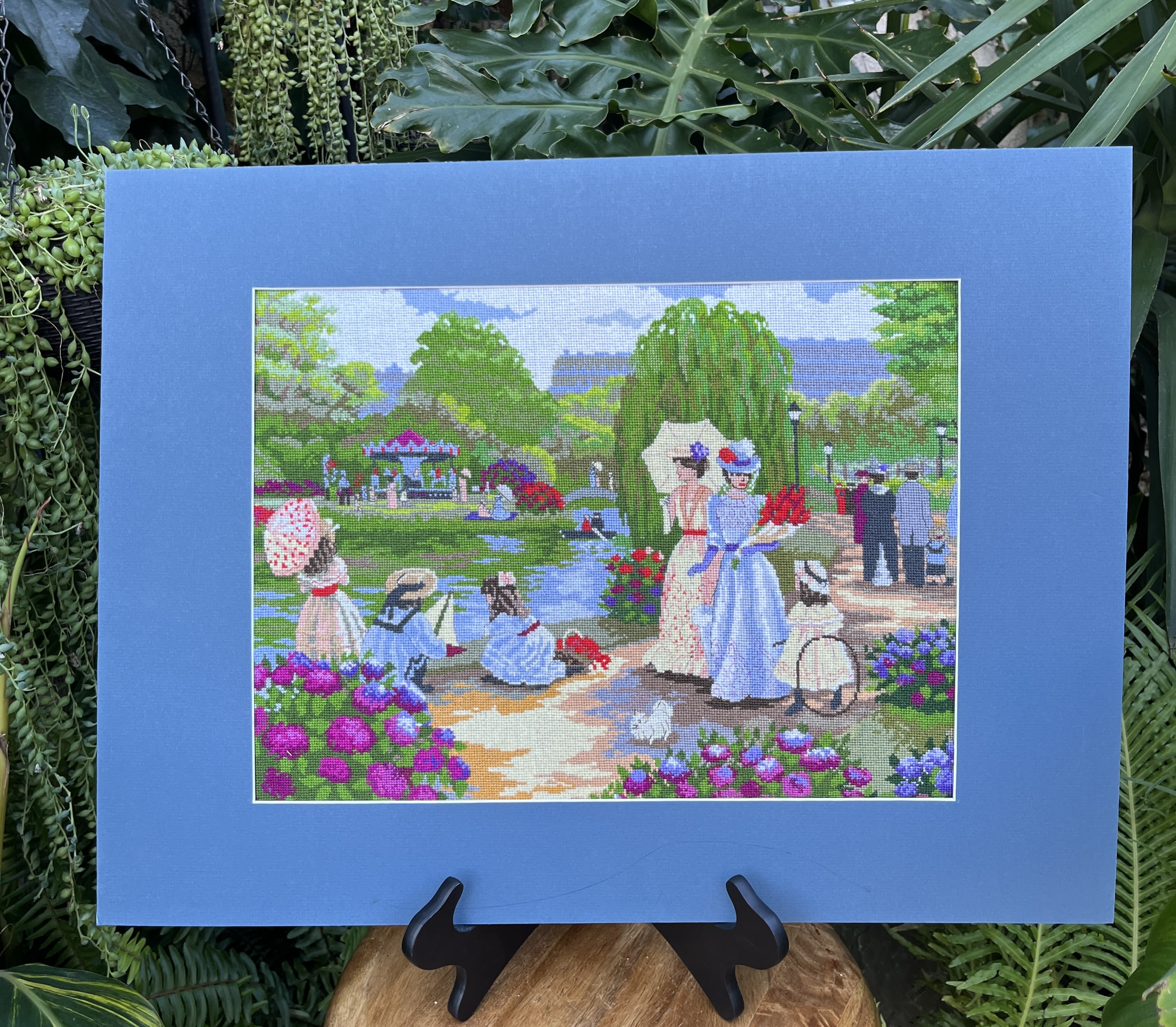 Blue-framed artwork showing women in a flower garden