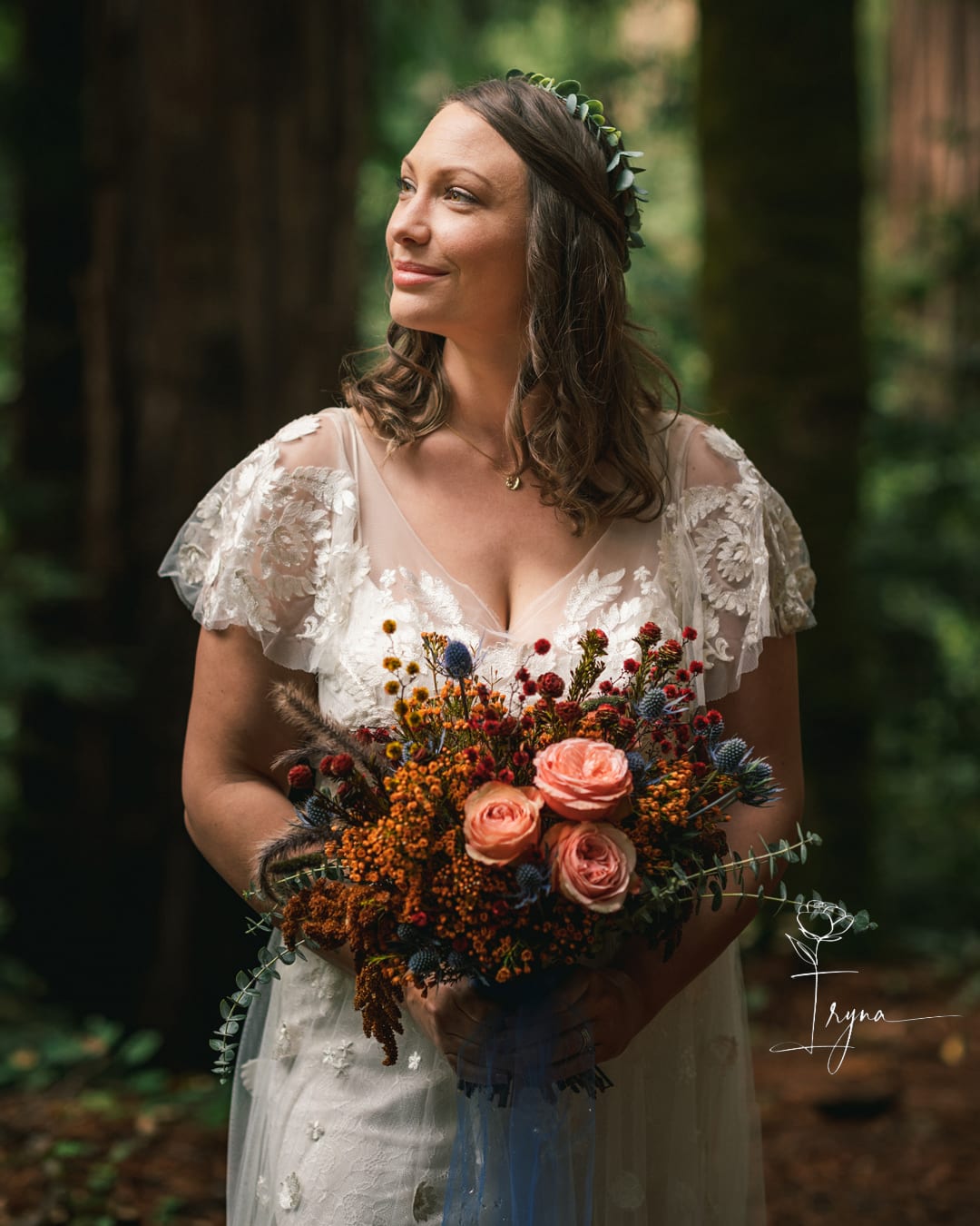 Bride holding a bouquet of peach roses and wildflowers