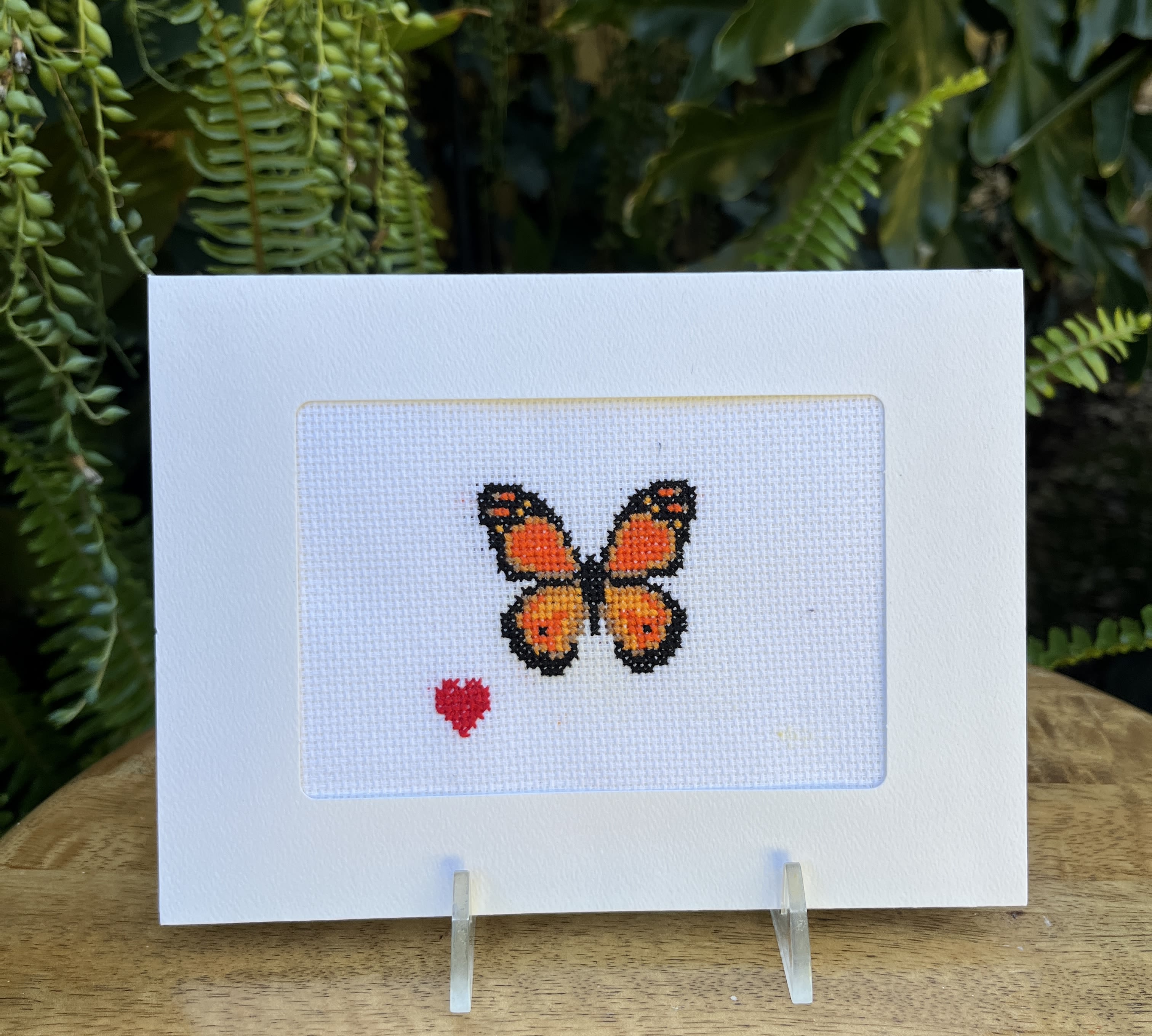 Cross-stitch card with an orange butterfly and small red heart
