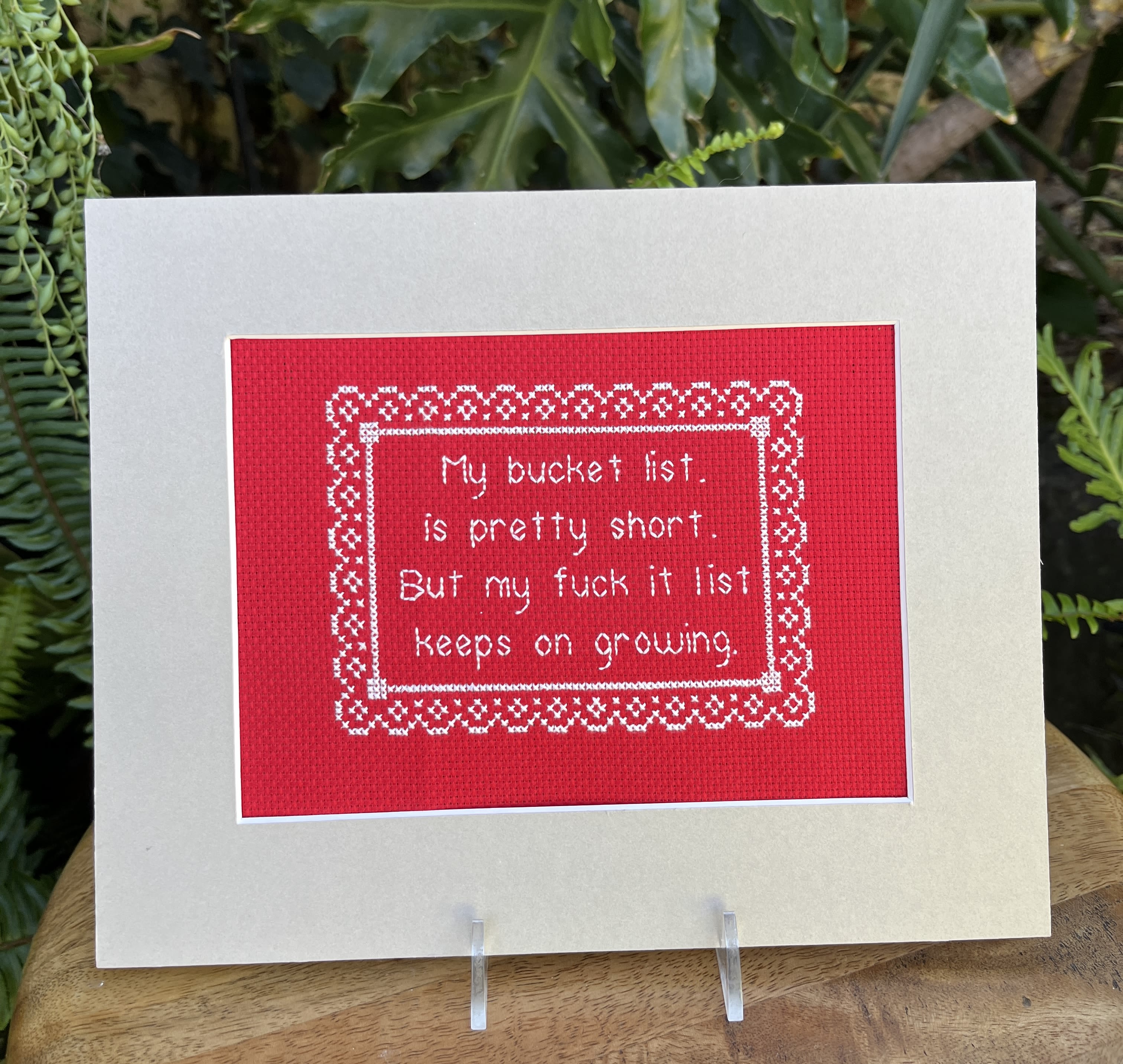 Greeting card with a red stitched message panel on a cream background