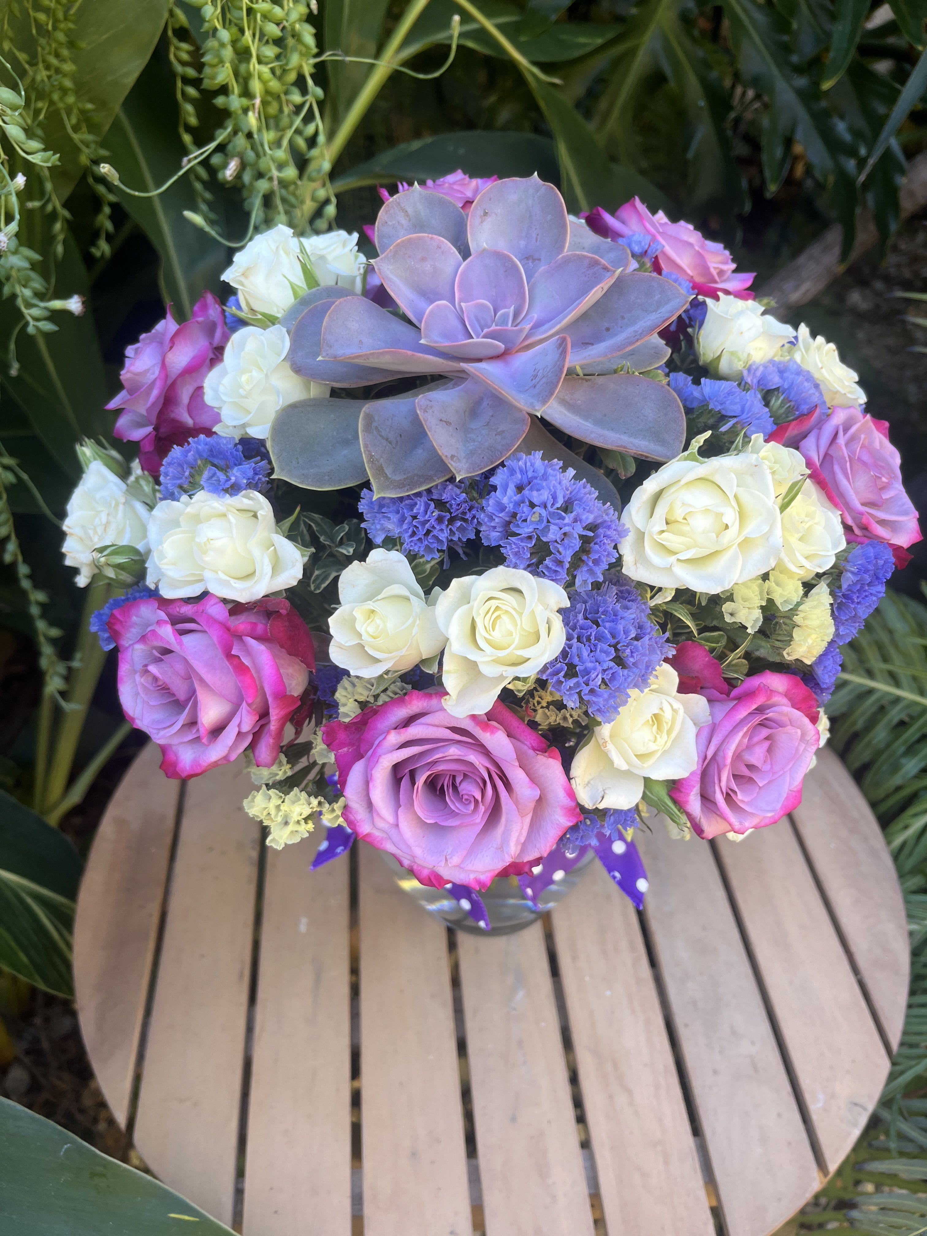 Bouquet of pink and white roses with a purple succulent centerpiece
