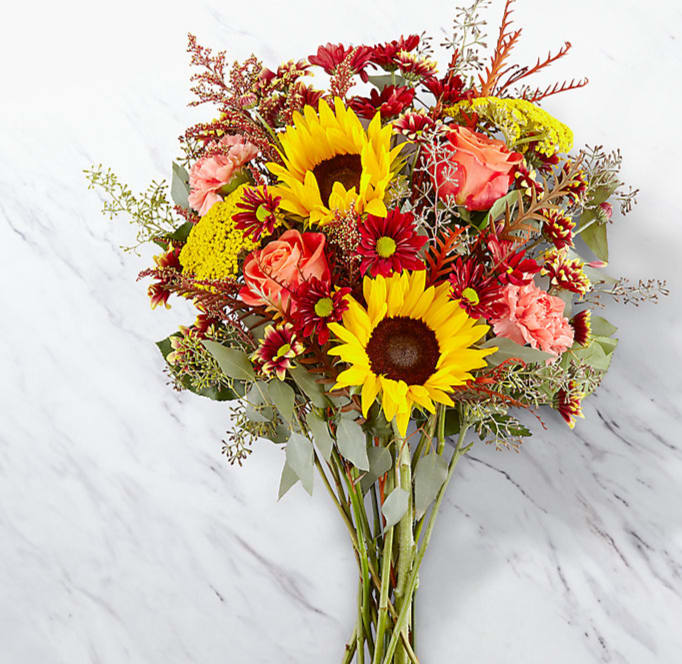 Copper Blessings  - Picked fresh from the farm, the Copper Callings Bouquet is full of warm color and bright beauty to send your happy harvest wishes across the miles! Hand gathered at select floral farms, this stunning bouquet or center piece brings together rich burgundies, soft oranges, and sunlit yellows to create a beautiful presentation. Picked fresh for you, this bouquet is the perfect way to say Happy birthday, thank you, or thinking of you this fall season. Bouquet includes: sunflowers, orange roses, orange carnations, yellow yarrow, red daisies, yellow daisies, red tinted solidago, orange tinted grevilia, seeded eucalyptus, and a vase or turned in to a one of a kind fall center piece. select upgrade for next level if you are wanting candles and a center piece made for your loved ones holiday table setting.