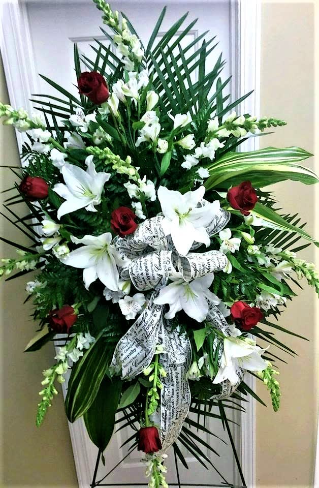 Standing sympathy spray with white lilies and red roses on a ribboned easel