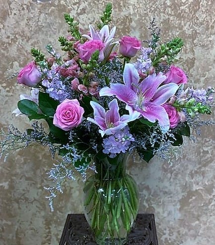 Pink roses and lavender lilies in a glass vase