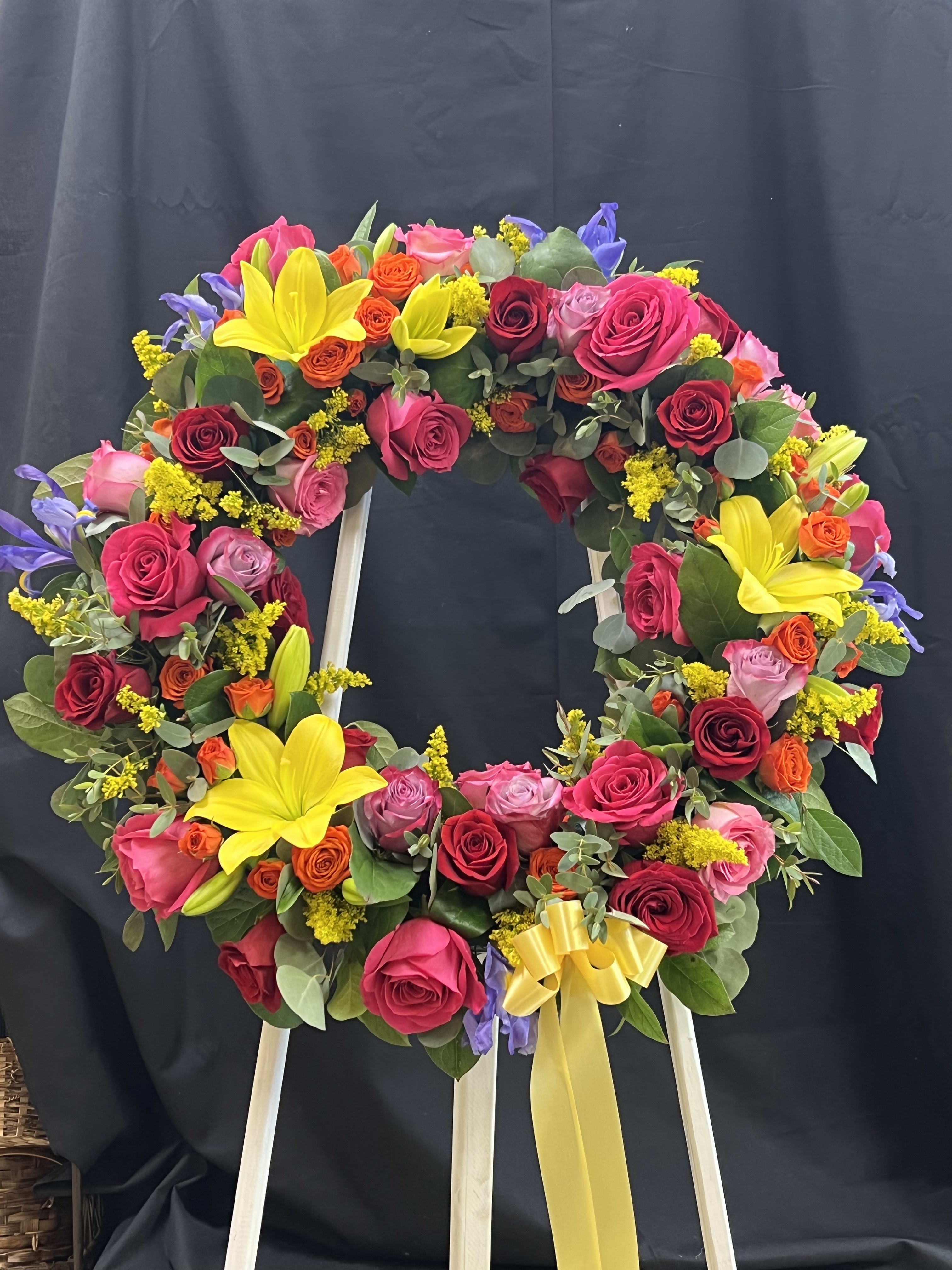 Colorful floral wreath on a stand with roses and lilies