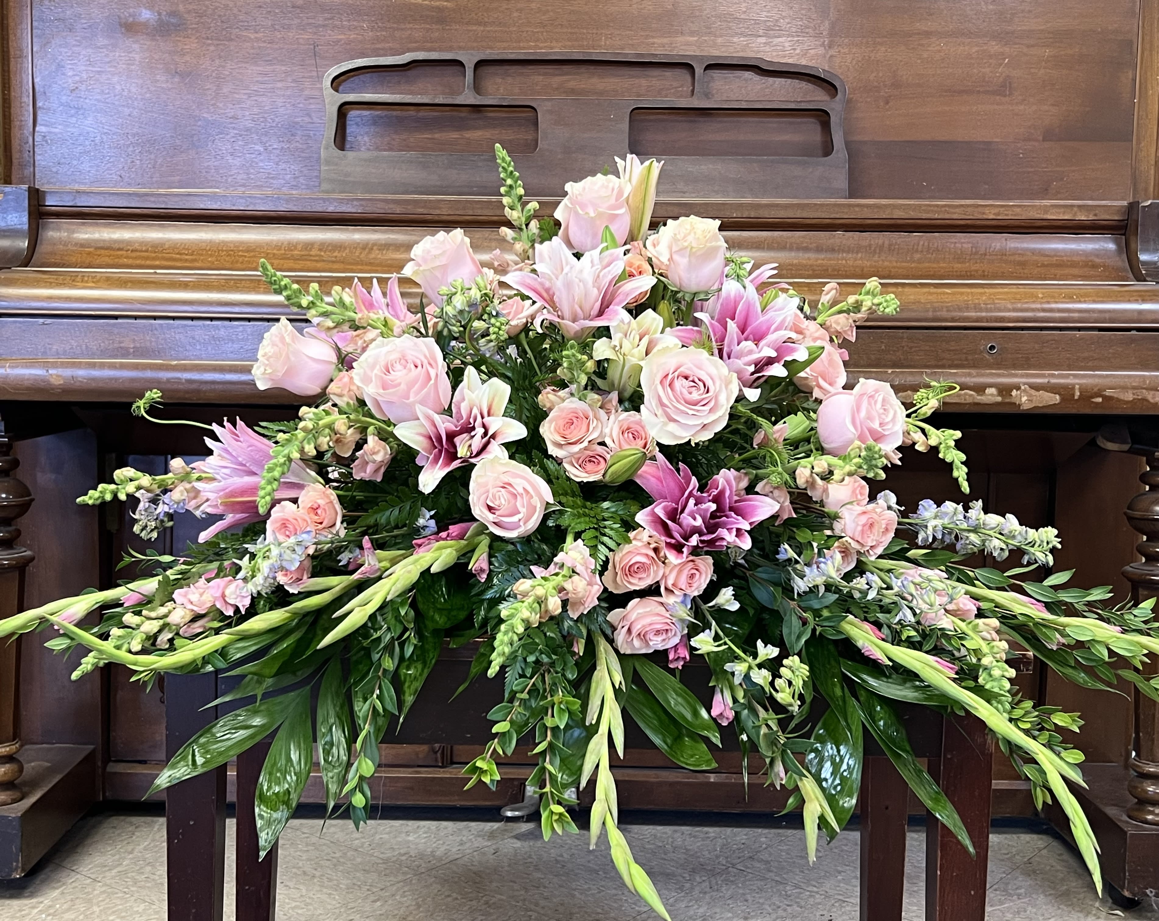 All pink casket spray - Standard shown-Express your sympathy with pink gladioli, Asiatic lilies and blooms in gentle shades of pink, lavender, accented with pink roses for love.