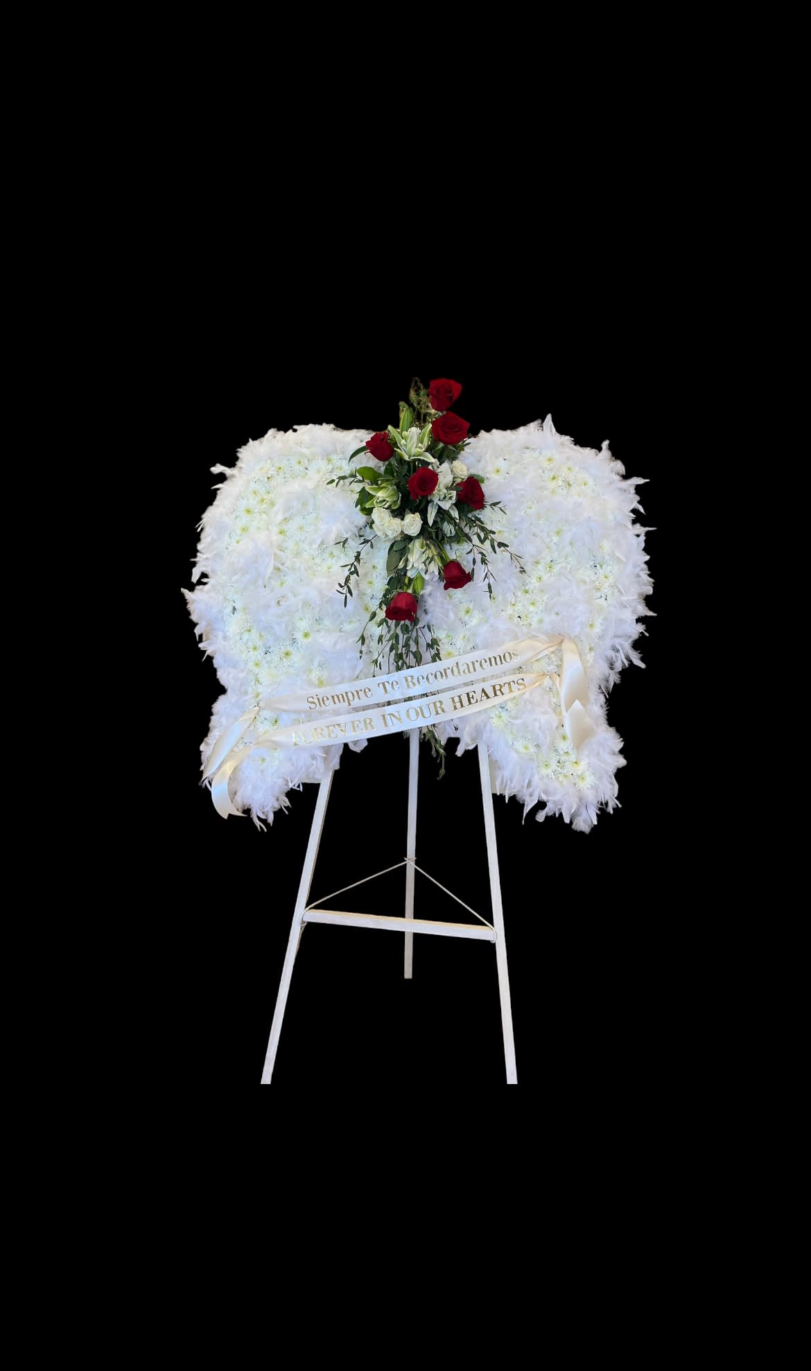 White funeral wreath with red roses on a standing easel