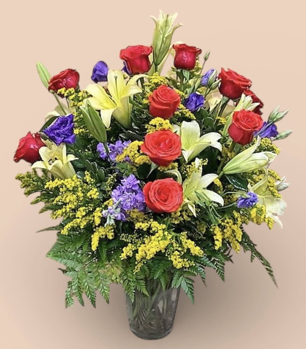 Bouquet of red roses and lilies in a clear glass vase
