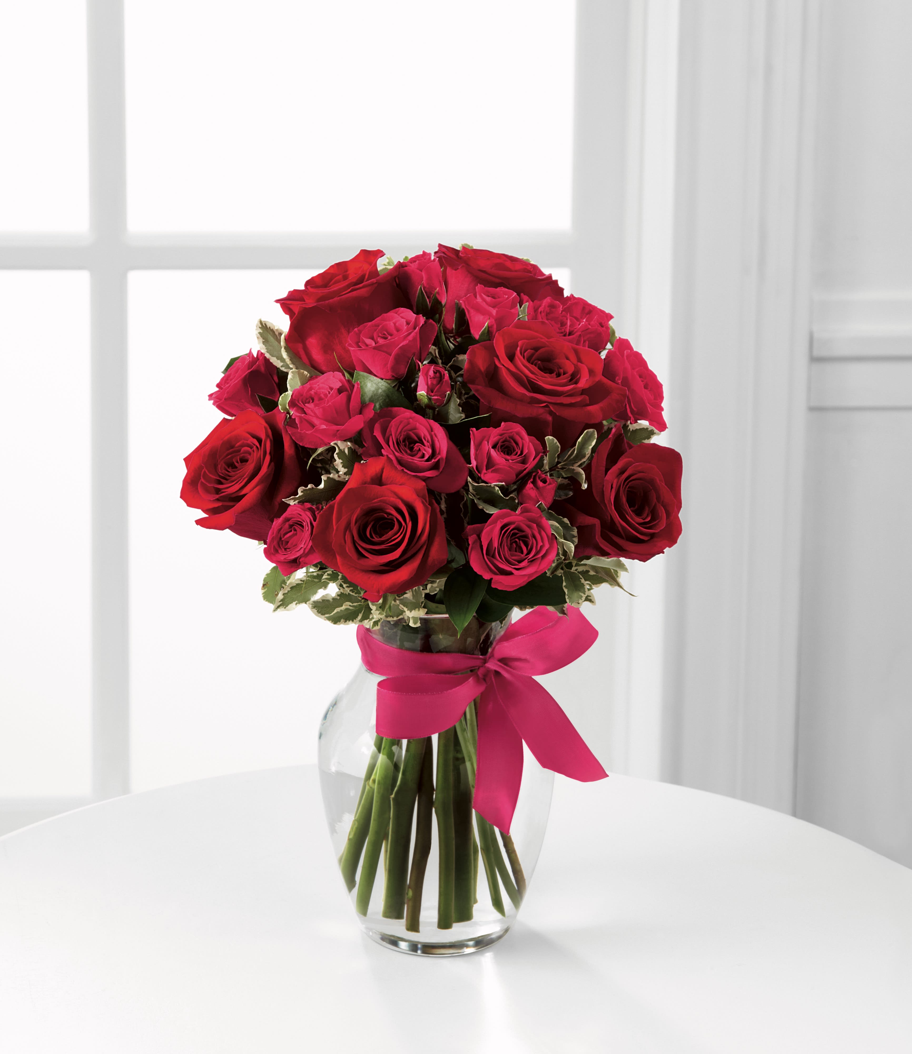  Love-Struck™ Rose Bouquet -  Love-Struck™ Rose Bouquet uses a touch of Cupid's magic this Valentine's Day to usher in romance and sweet love.  Bright red roses and hot pink spray roses are artfully arranged amongst lush greens in a clear glass vase tied with a taffeta bi-colored ribbon to create a bouquet of passion and beauty.