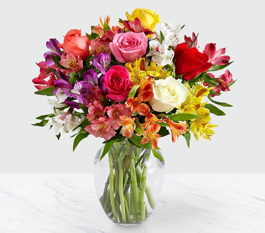 Smiles &amp; Sunshine with Glass Ginger Vase - Send a sunny splash of color and brighten their day with this vibrant bouquet of 10 Peruvian lilies, mixed with 6 multi-colored roses. Symbolic of friendship and devotion, each stem of Peruvian lily has multiple blooms and is sure to warm their heart.  