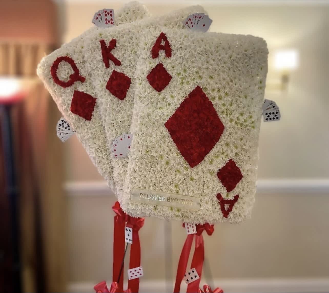 Floral arrangement shaped like playing cards with red suit symbols
