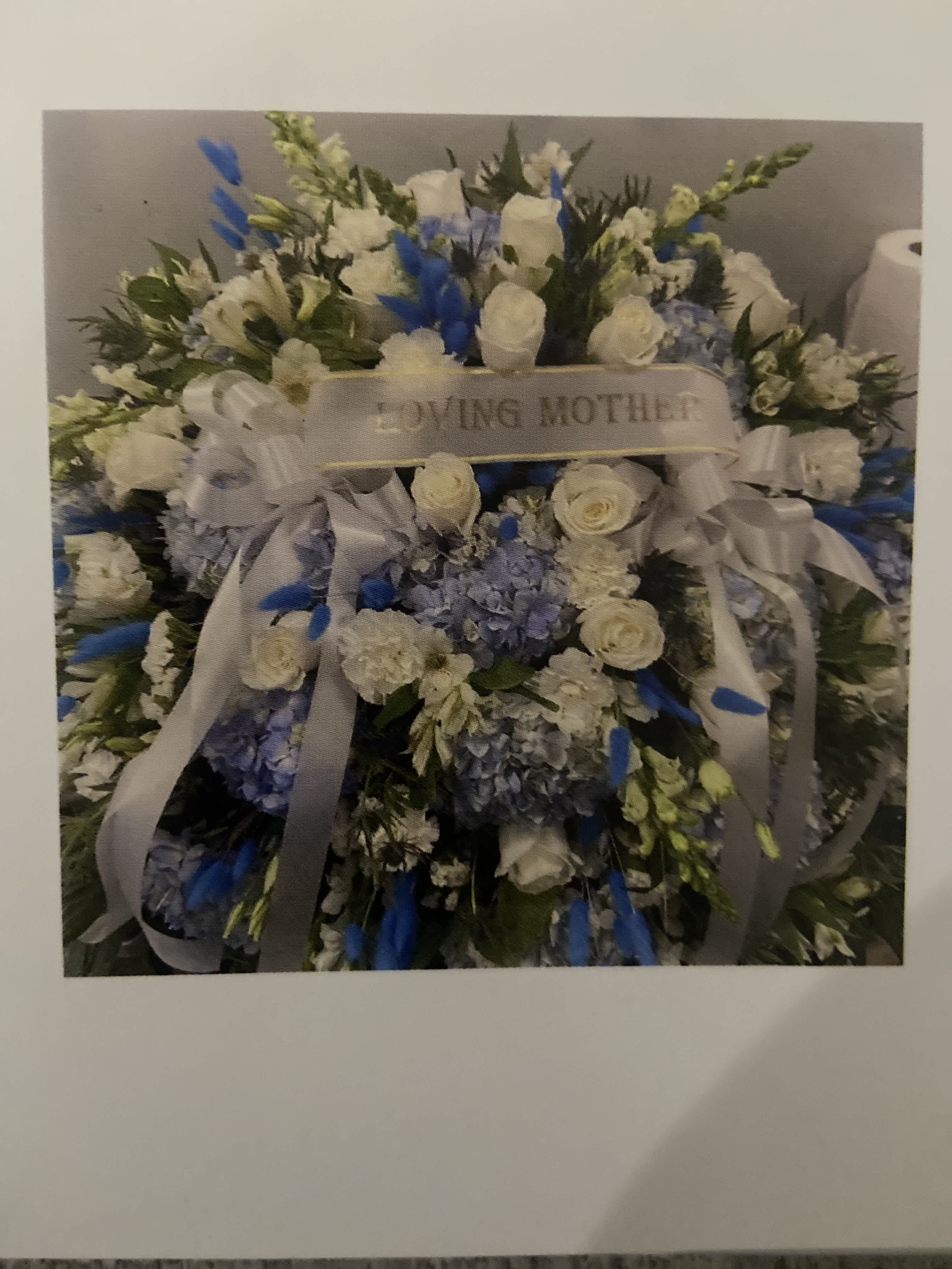 Large white and blue floral spray with a "Loving Mother" ribbon
