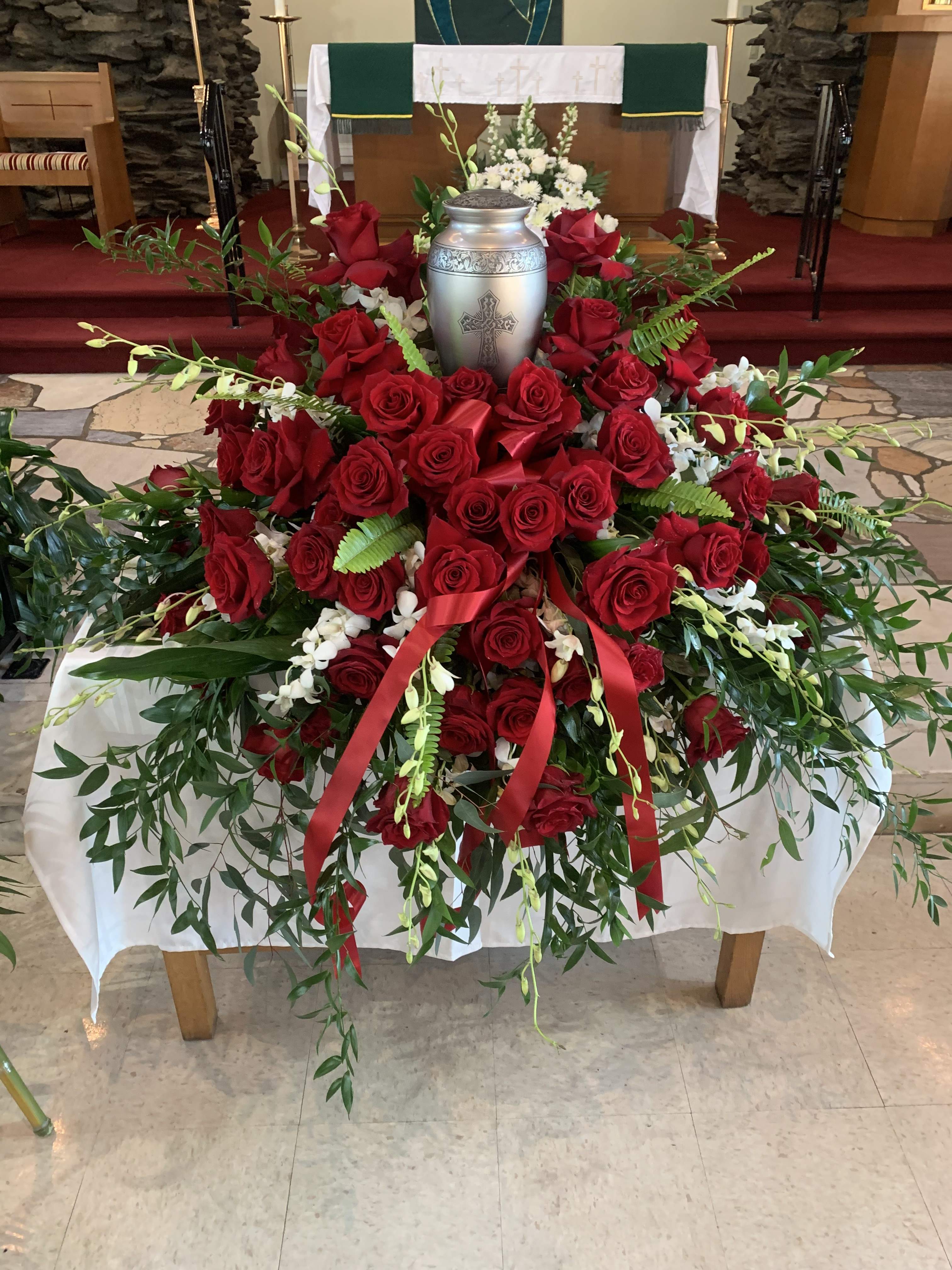 Red rose funeral spray with a silver urn centerpiece