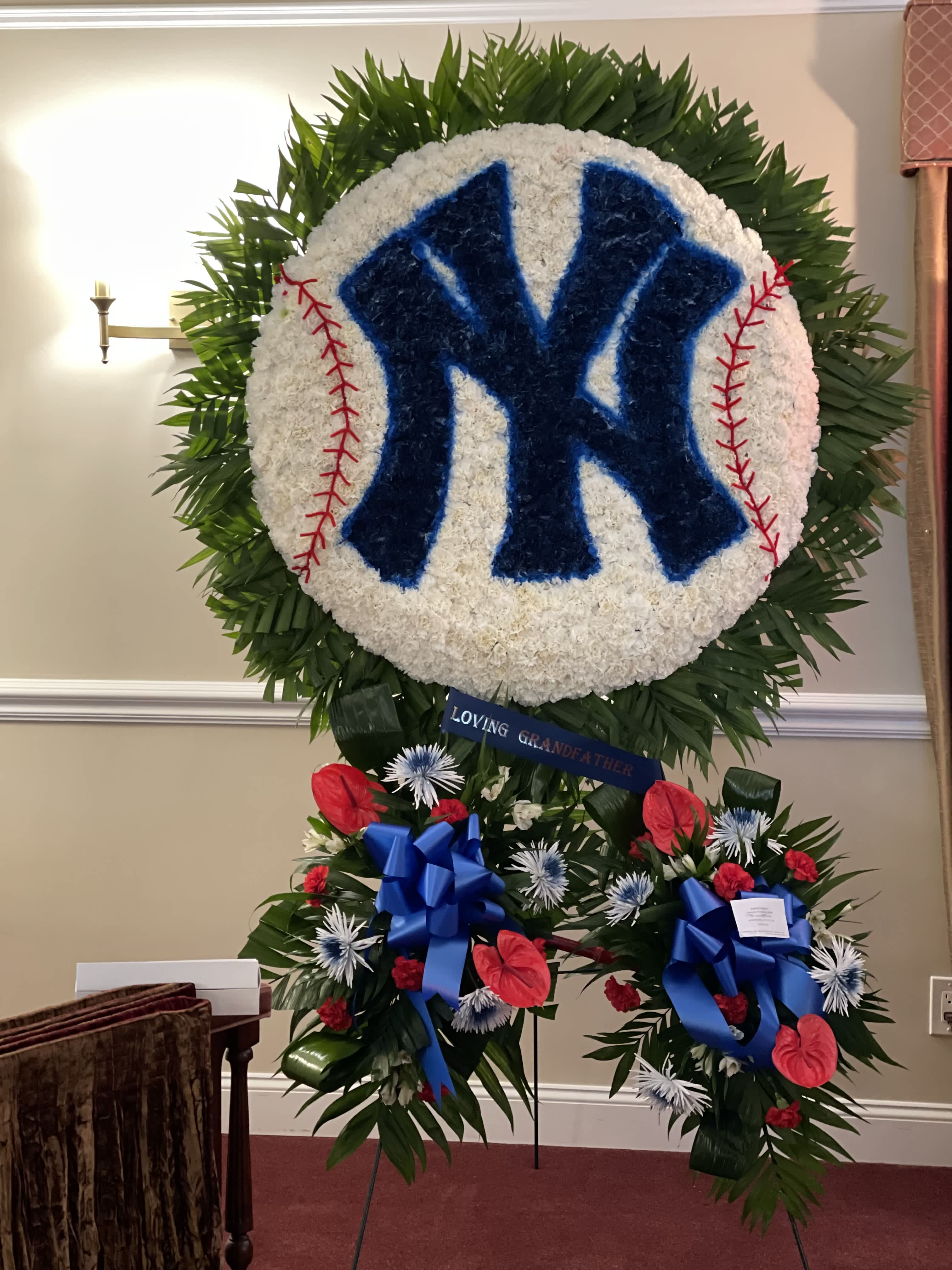 Large floral tribute shaped like a baseball with a Yankees logo