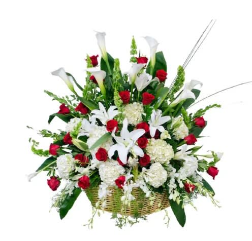 Basket arrangement of red roses and white calla lilies