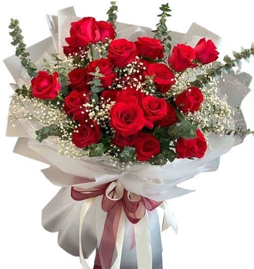 Bouquet of red roses wrapped in white paper with a ribbon