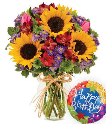 Bouquet of sunflowers, red flowers, and purple daisies in a glass vase with a birthday balloon