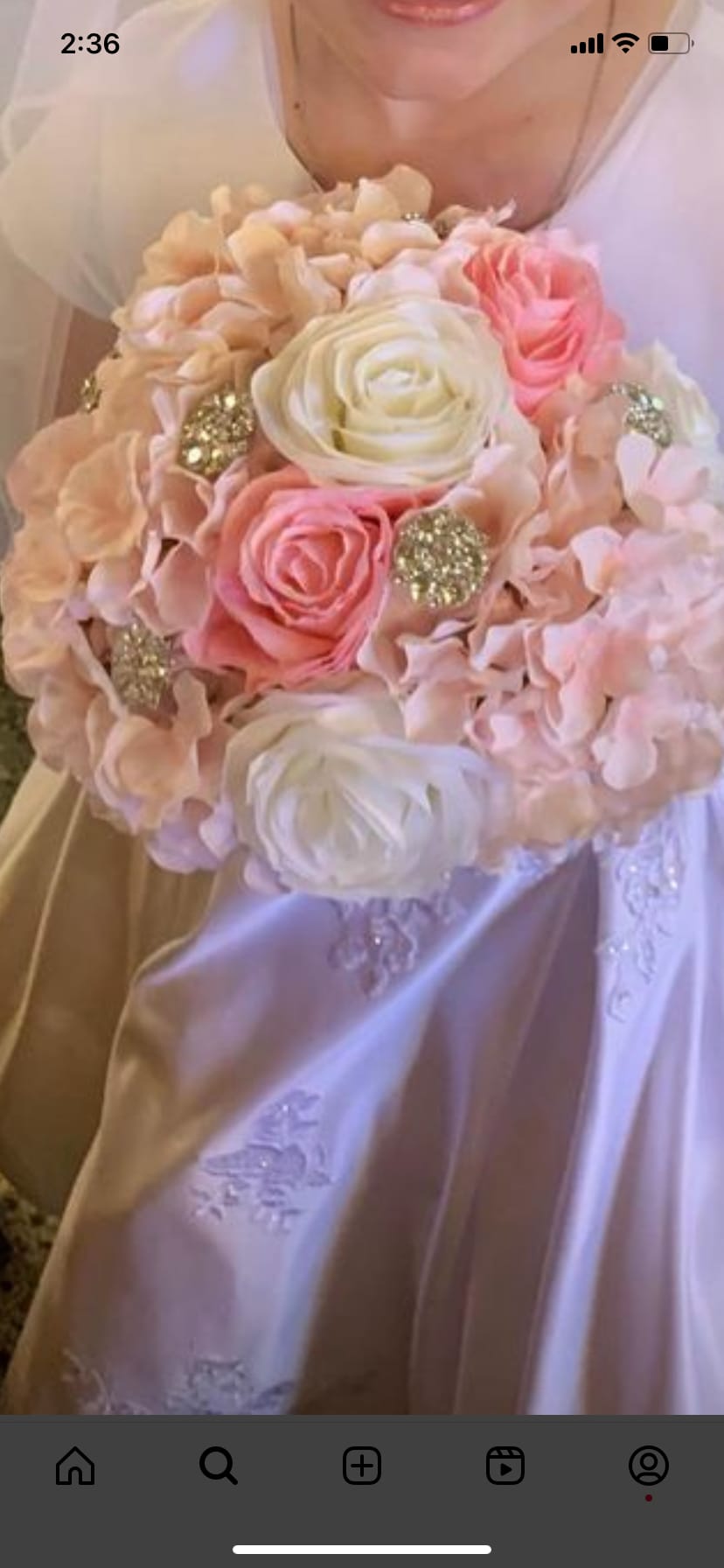 Bride holding a pastel bouquet of roses and hydrangeas with glitter accents