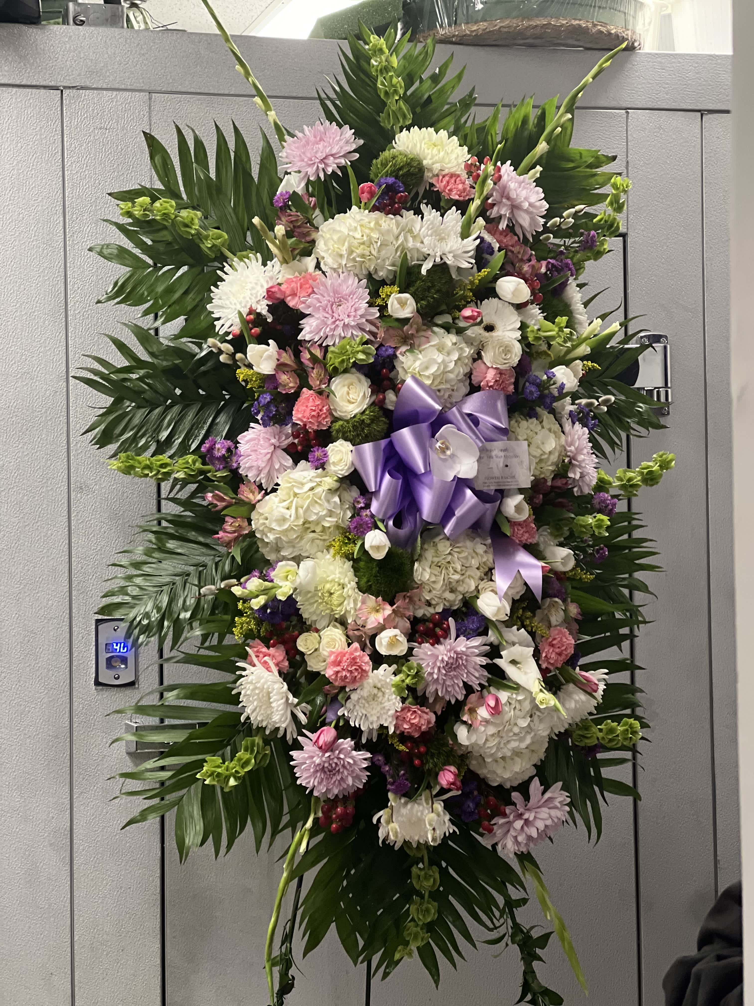 Large standing floral spray with pink, white, and purple blooms