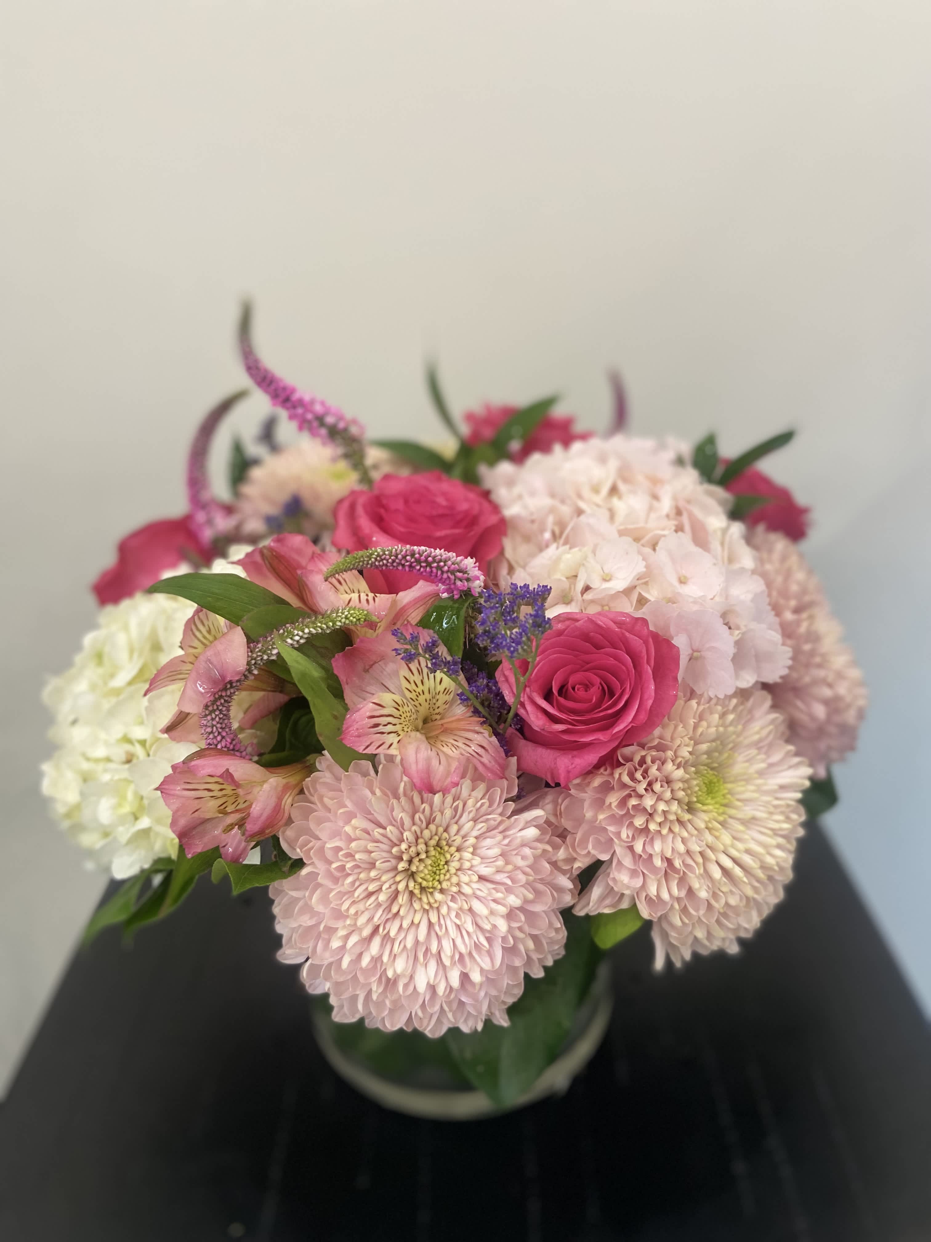 Pink roses and pale chrysanthemums in a glass vase