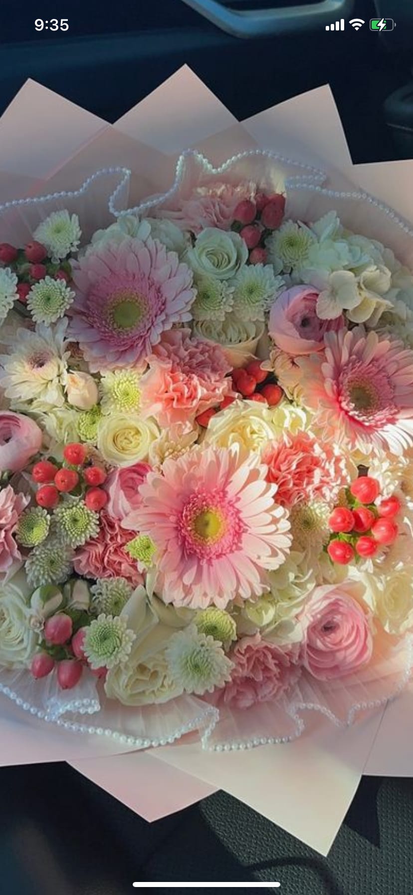 Bouquet of pink and white mixed flowers wrapped in pale paper