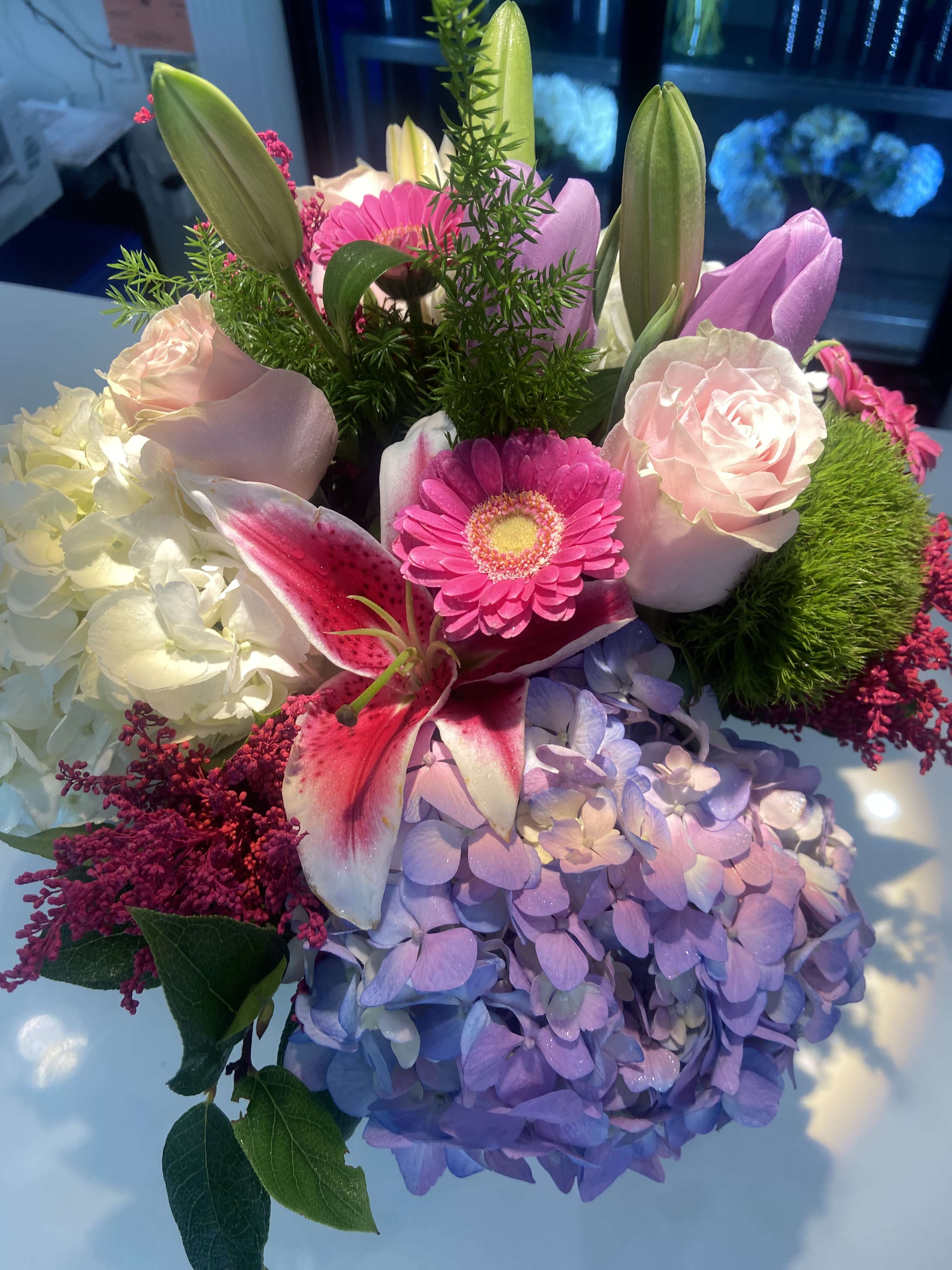 Bouquet of pink lilies, roses, hydrangea, and a gerbera daisy